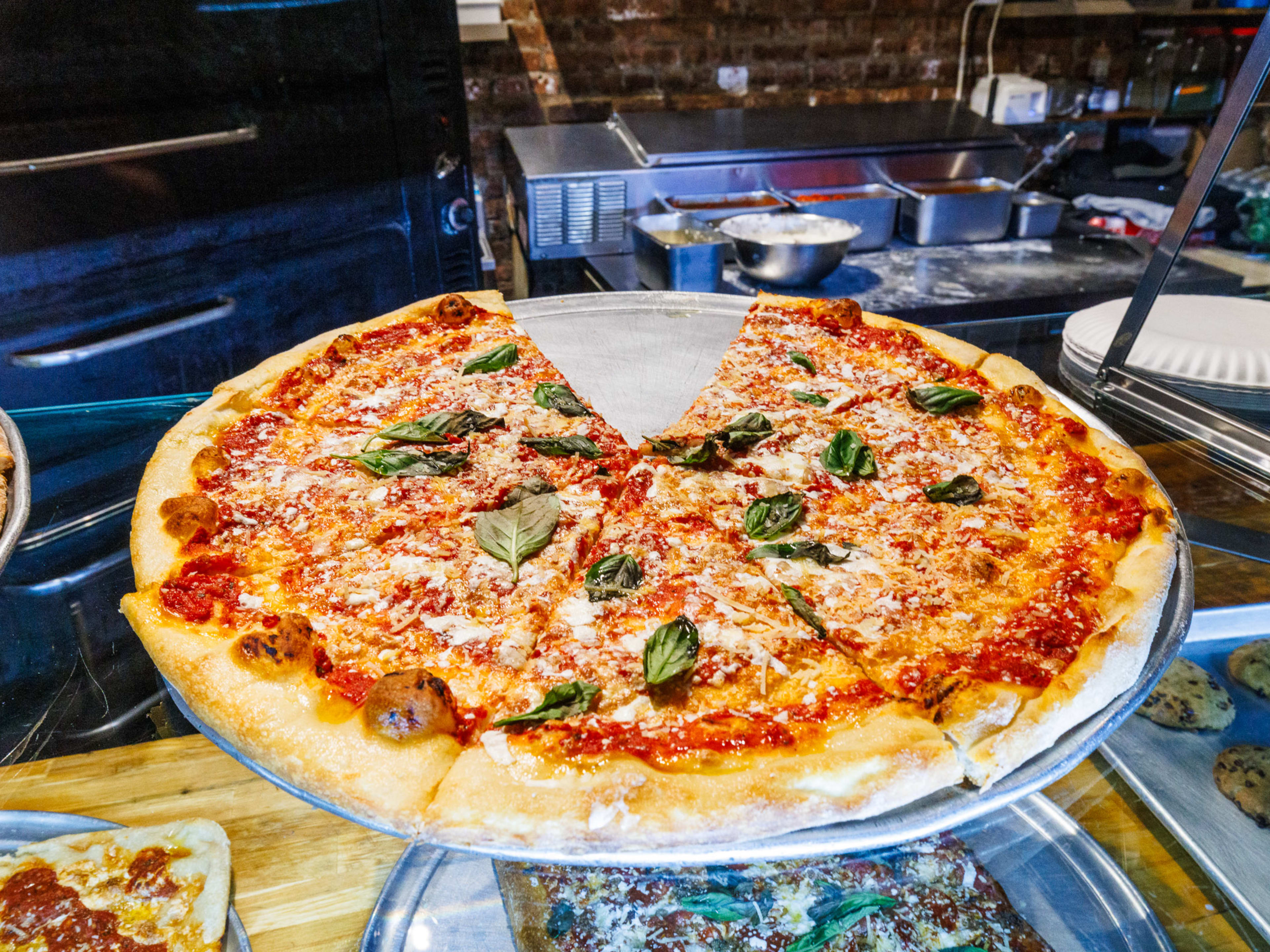 Brooklyn Pizza Market pizza with basil on a metal tray