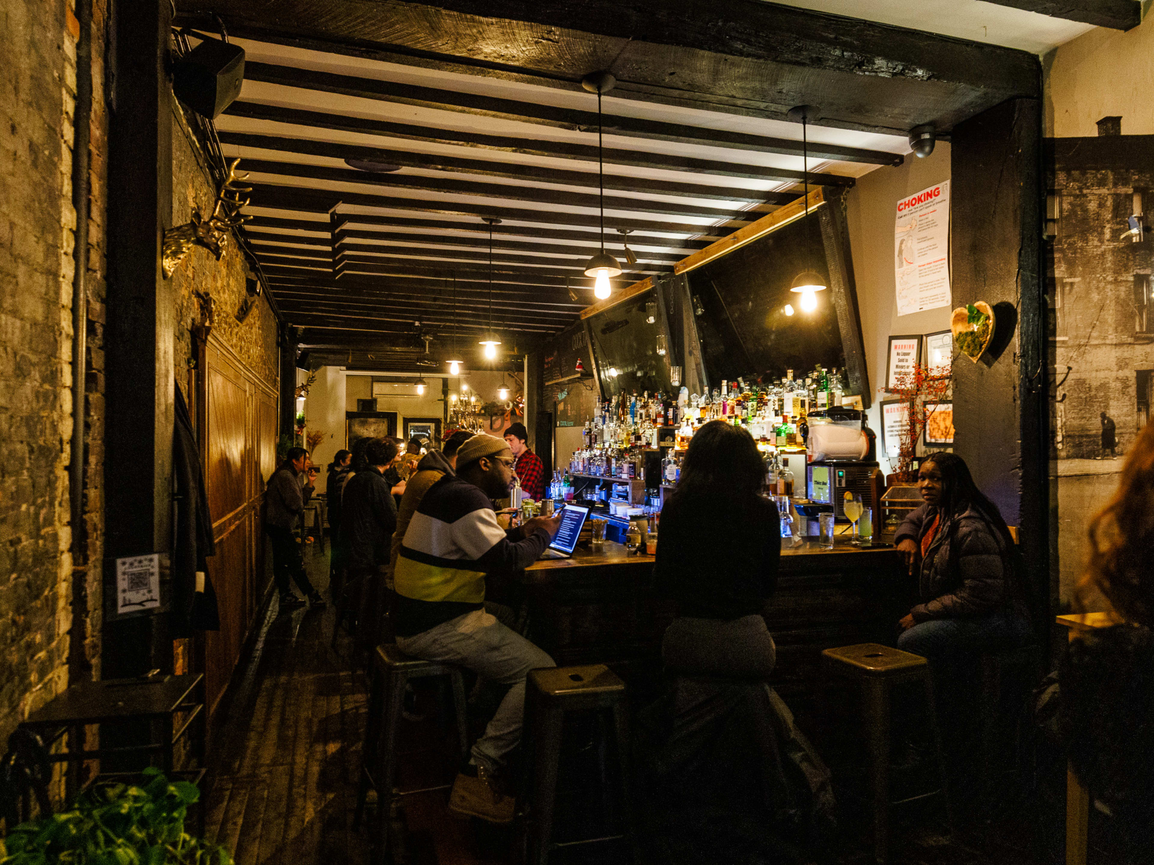 Cocktail Bedstuy interior with dim lighting and people sitting around the bar