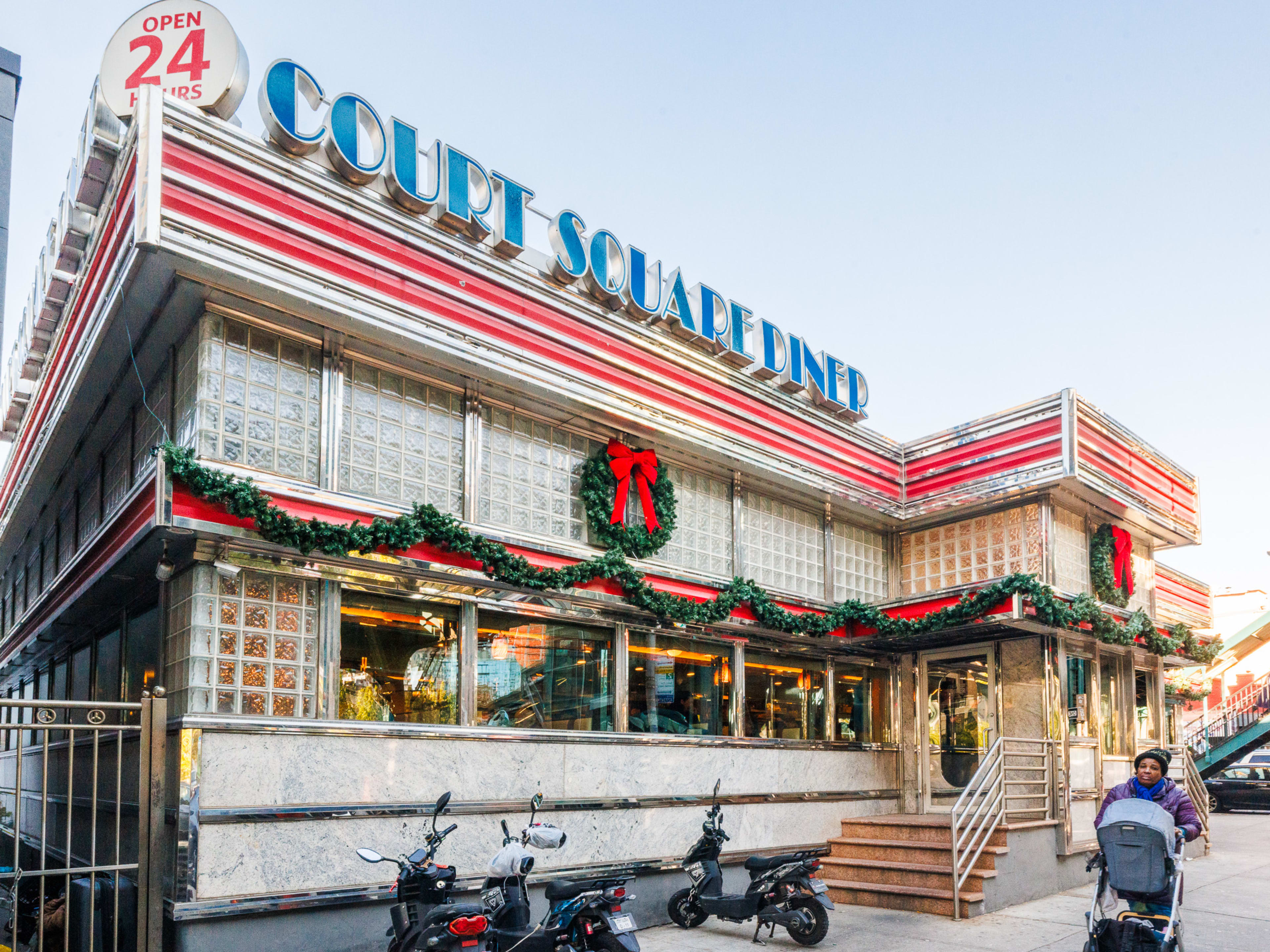 Court Square Diner exterior with classic retro diner sign and large holiday garlands and wreaths hung up