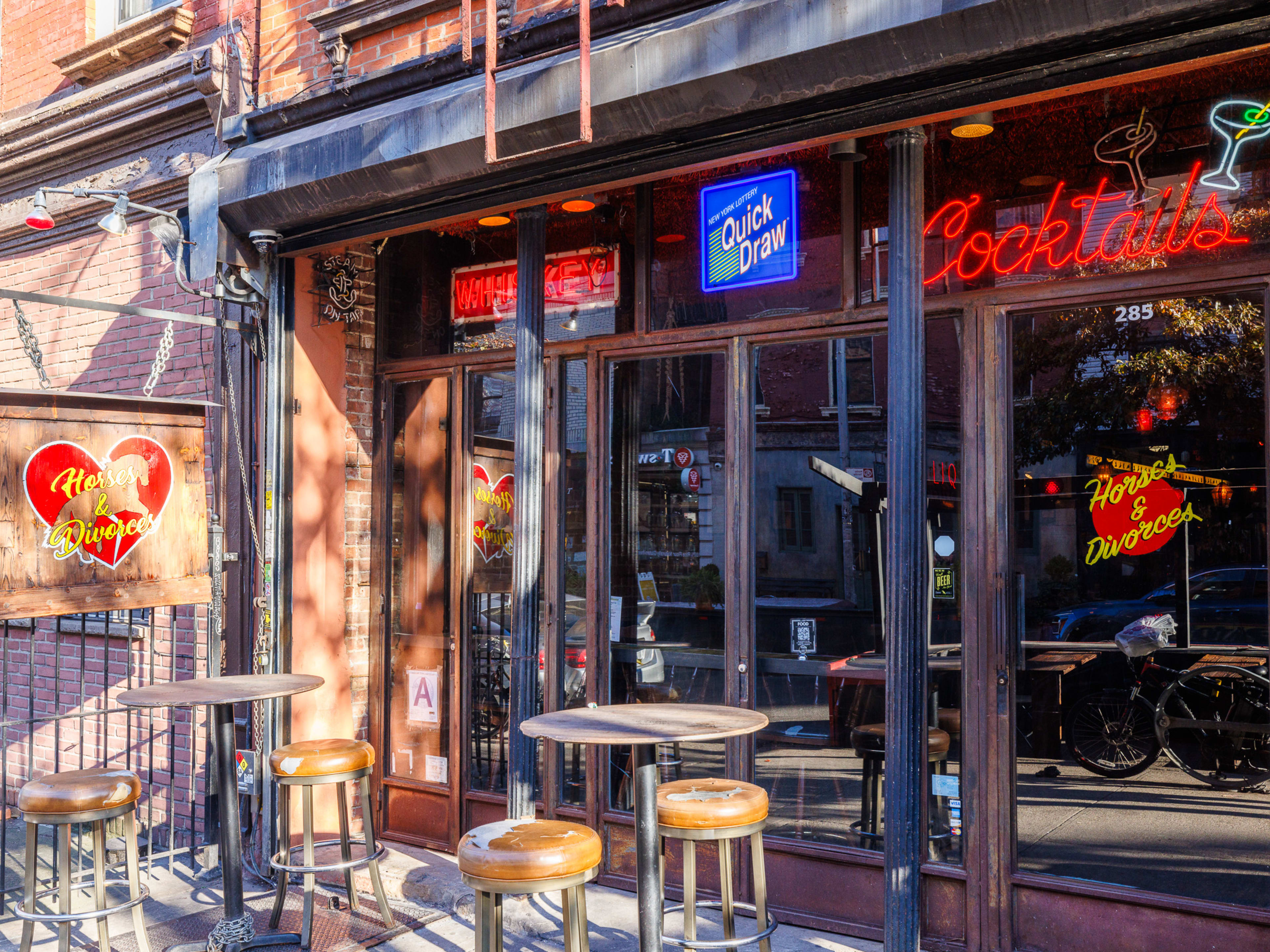 Exterior at Horses And Divorces with neon signs and outdoor high top seating