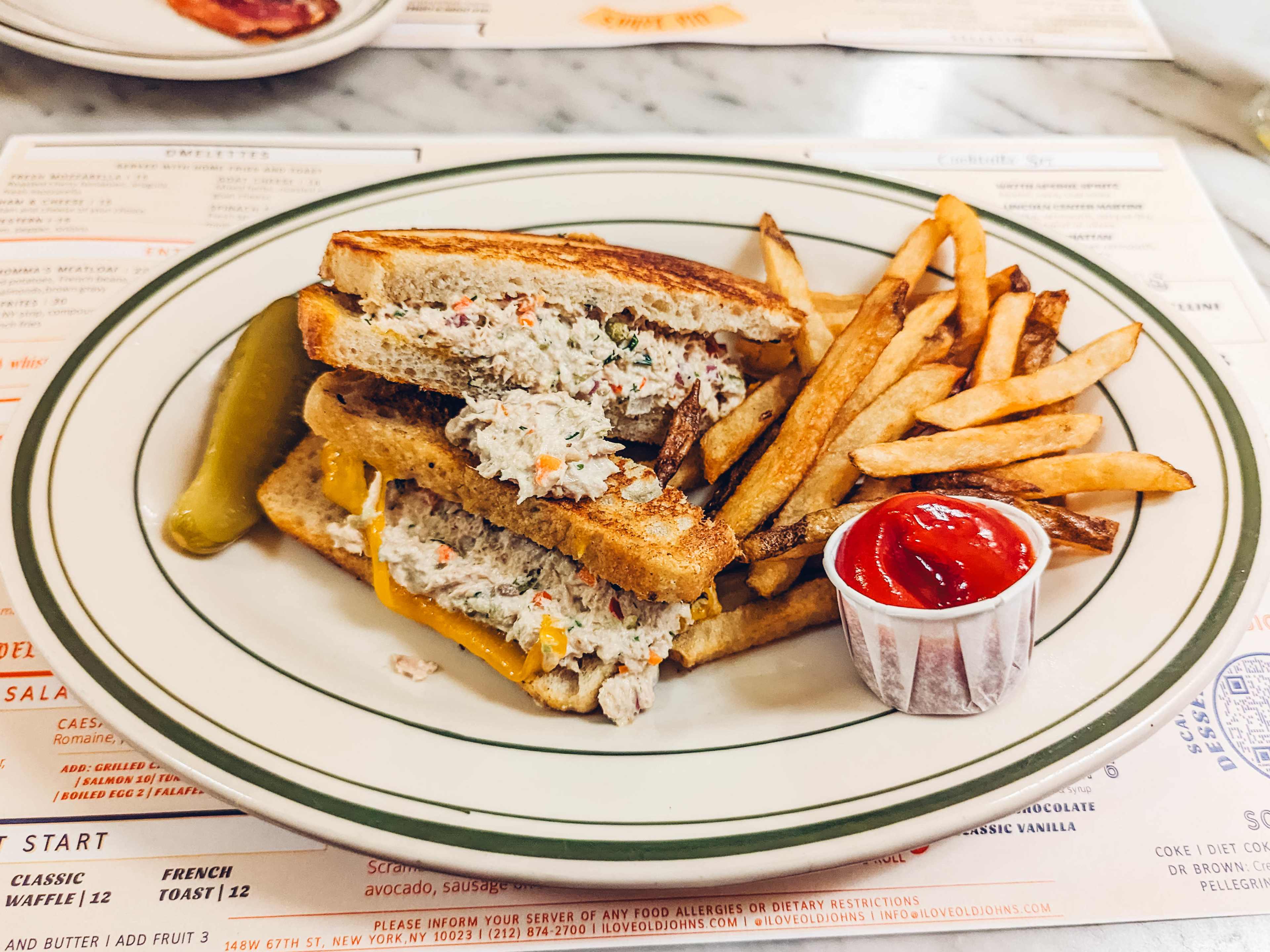 tuna melt sandwich served with fries and a pickle