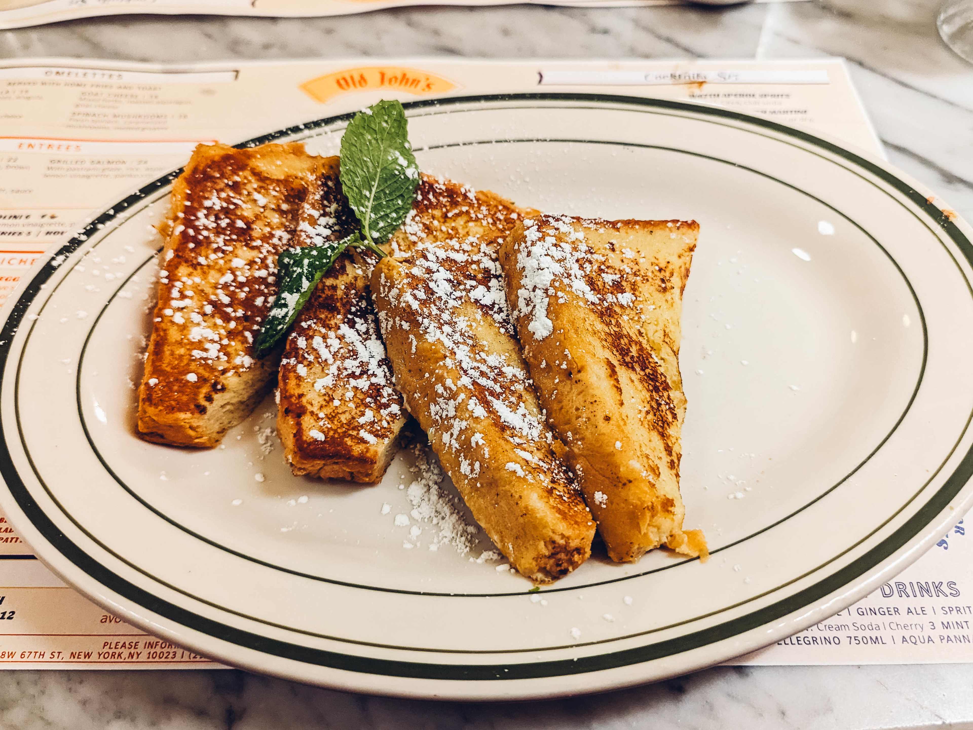 four half-slices of French toast with powdered sugar and a sprig of mint