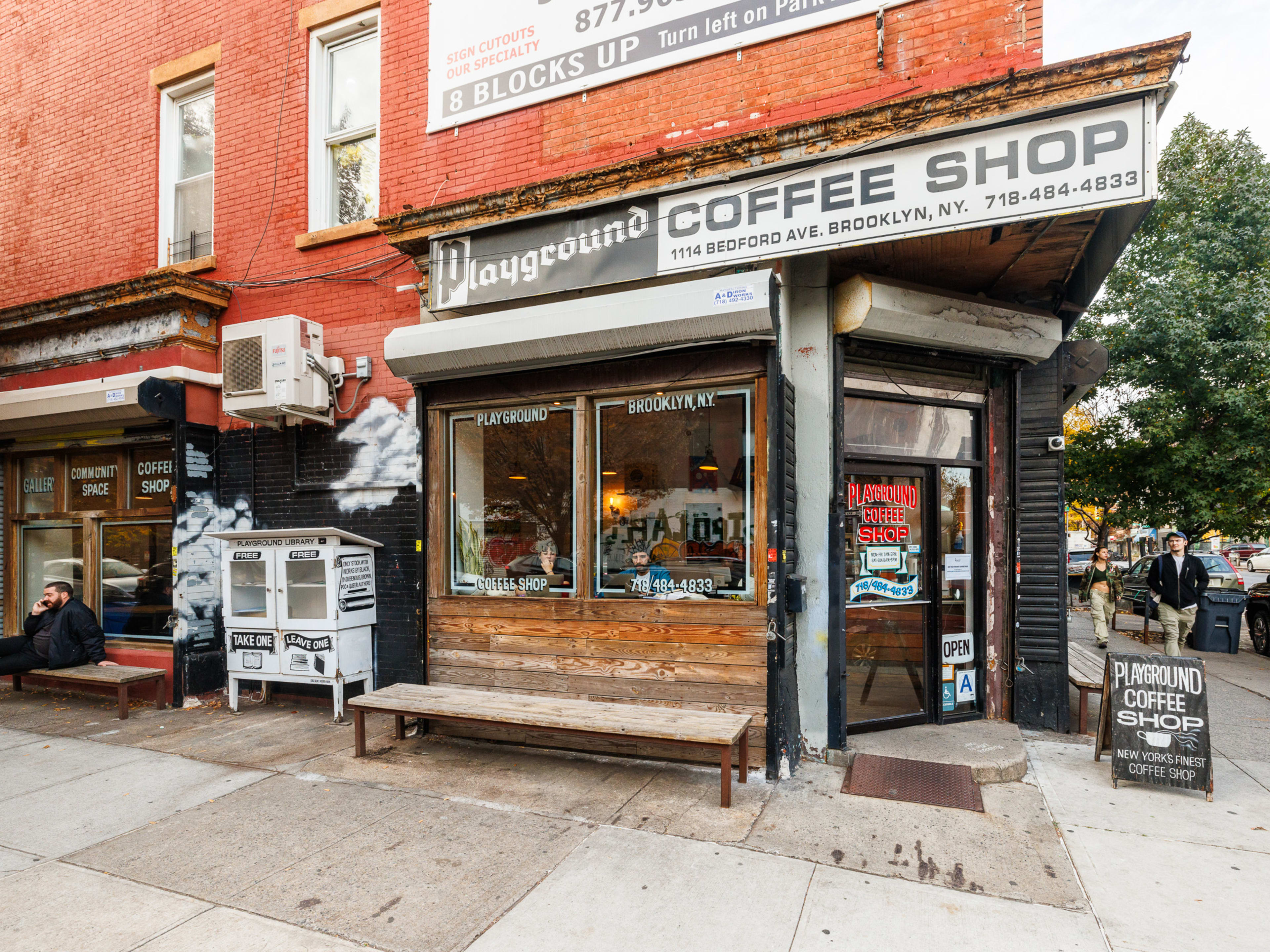 Playground Coffee Shop exterior with wood paneling and a bench on the sidewalk