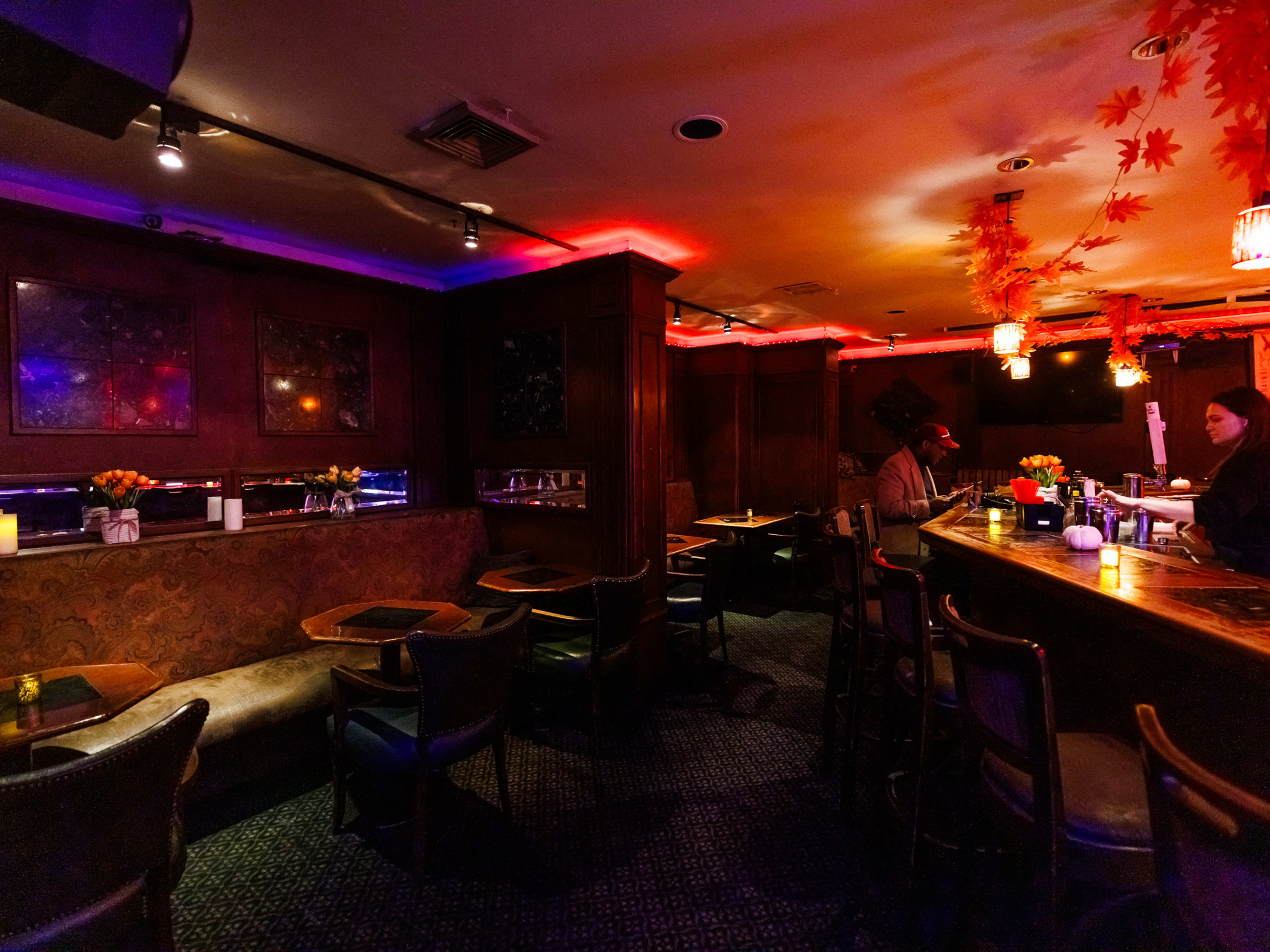 Russian Vodka Room dark interiors with red lighting and octagonal wooden tables with booth seating