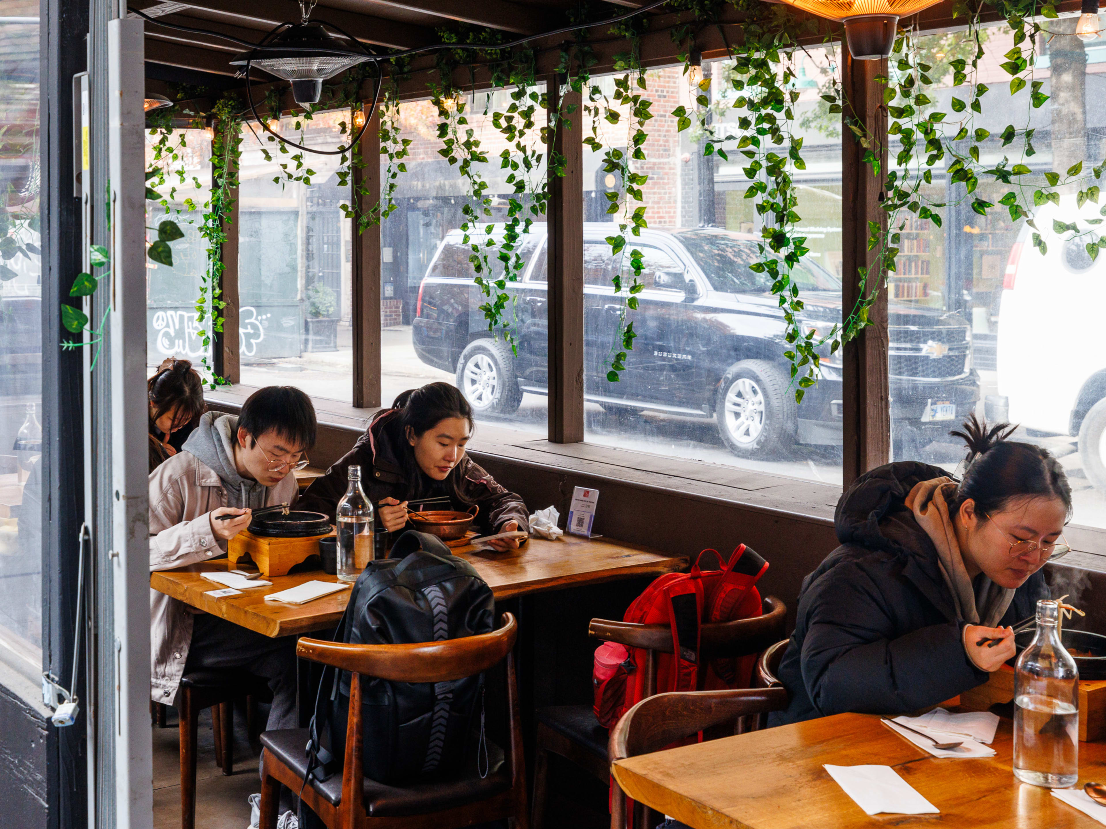 South Of The Clouds outdoor seating area in the street with people eating noodles in winter coats