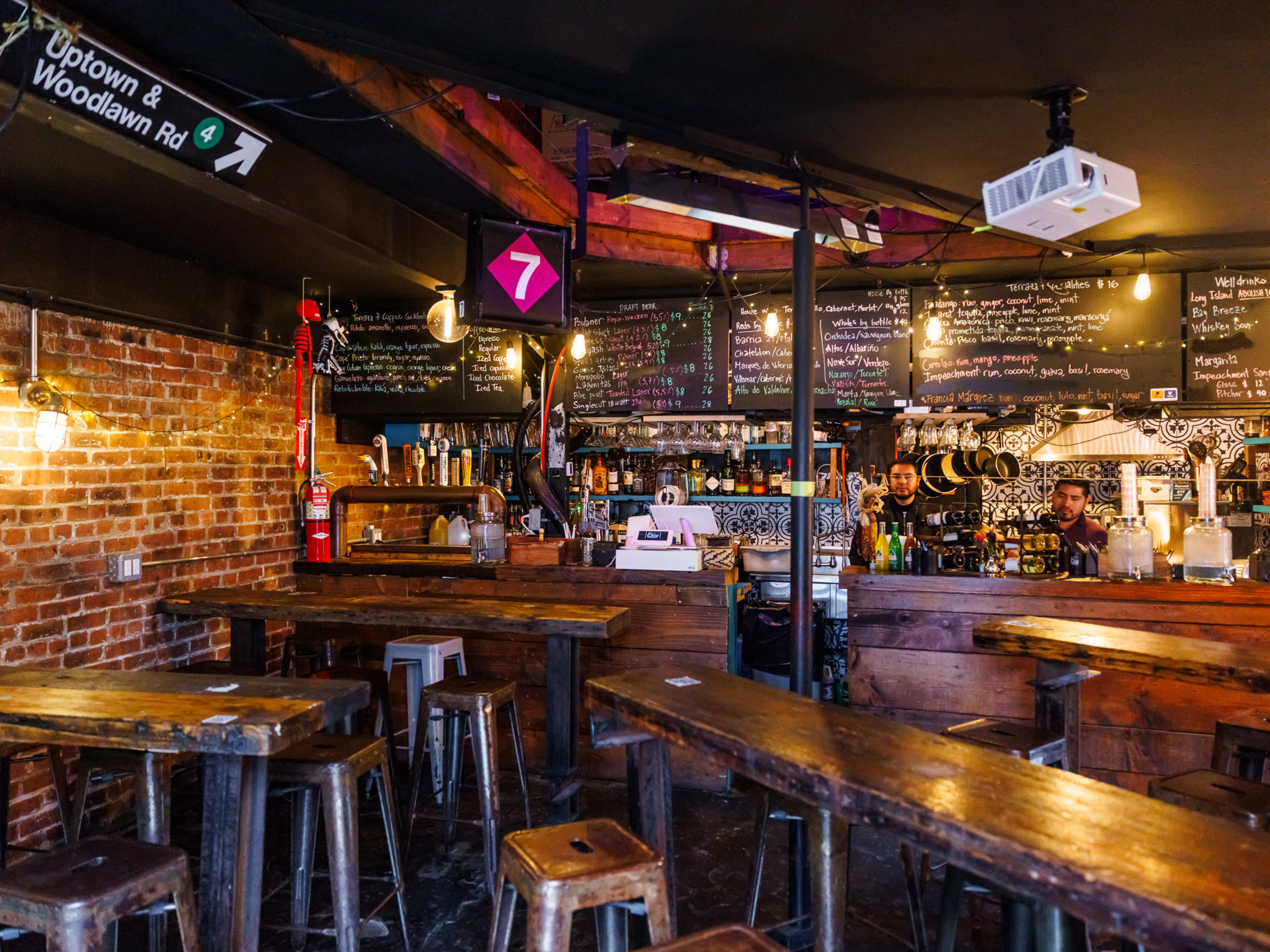 Terraza 7 interior with wooden high top seating, brick walls, and a chalkboard menu