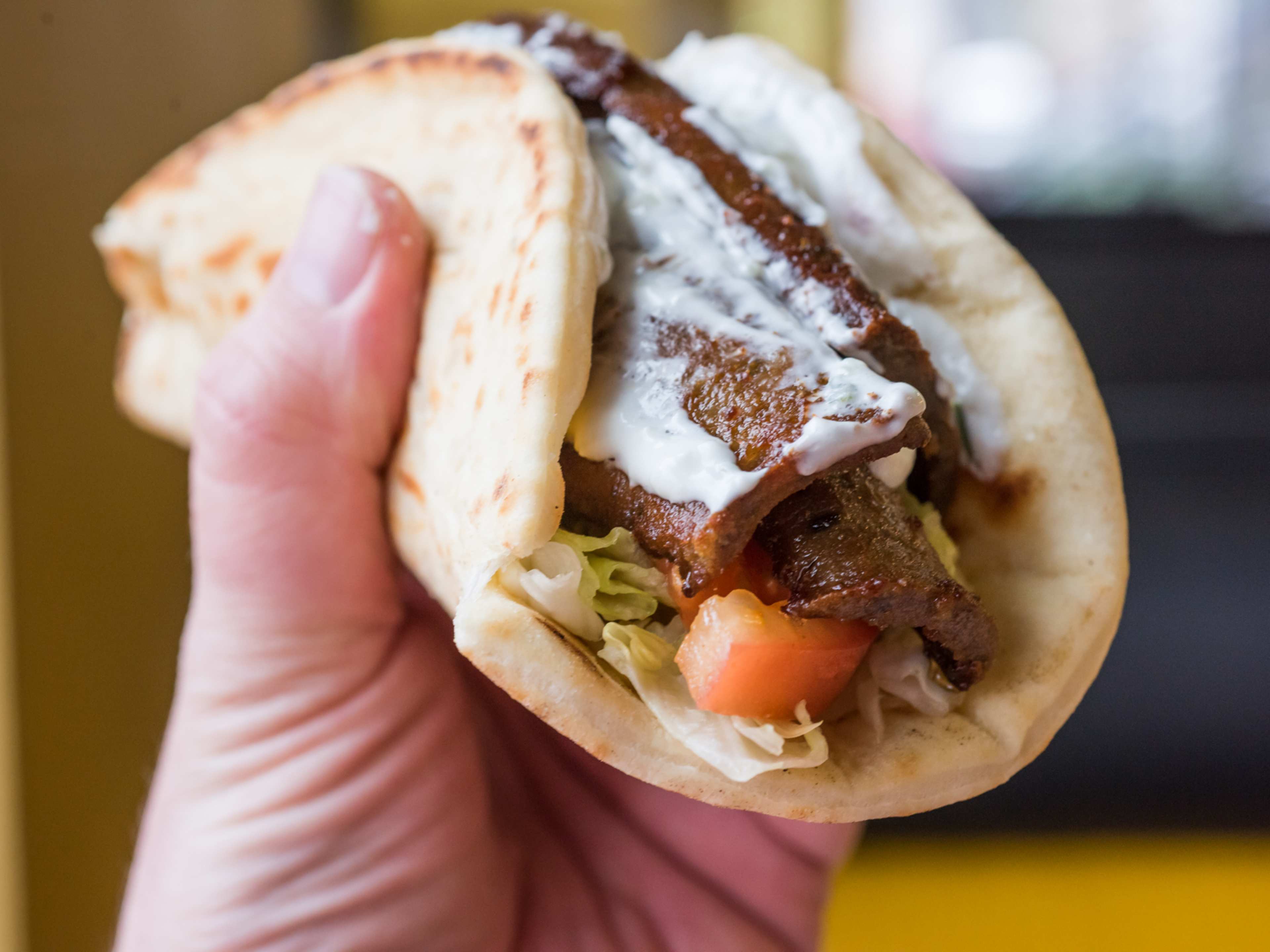 hand holding lamb and beef gyro