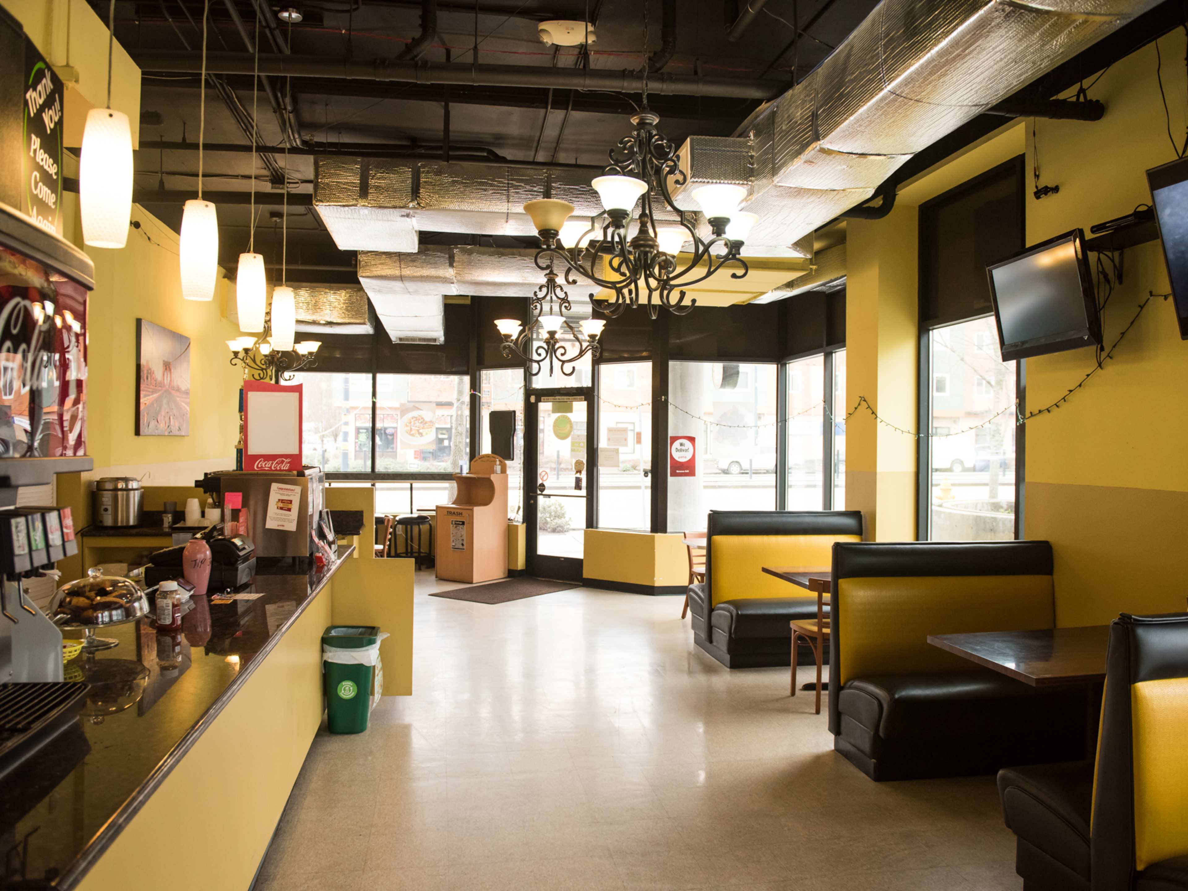 casual interior of restaurant with booths, tvs, and an order counter