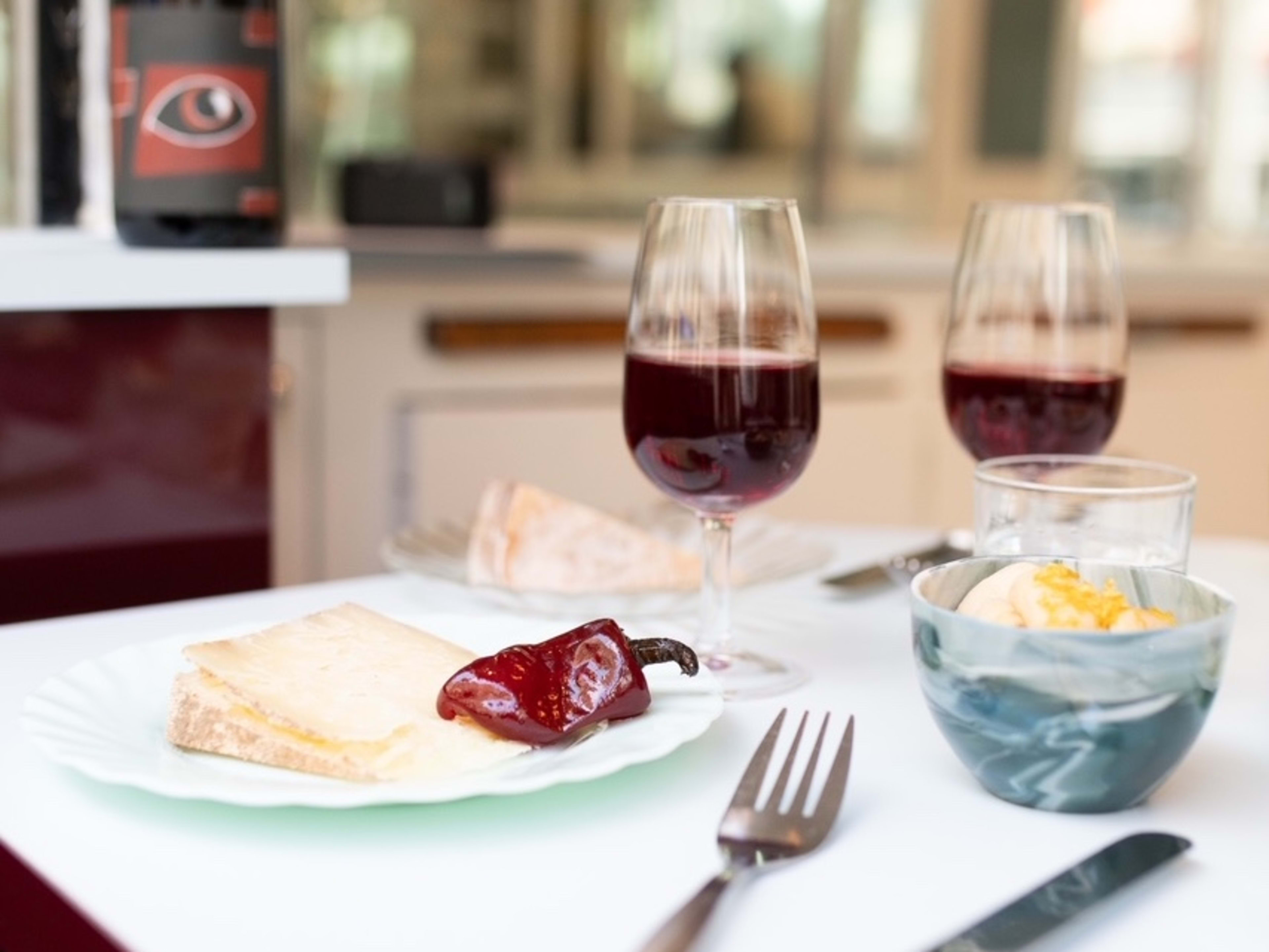 Plates of cheese and glasses of red wine at Olga Vins et Fromage