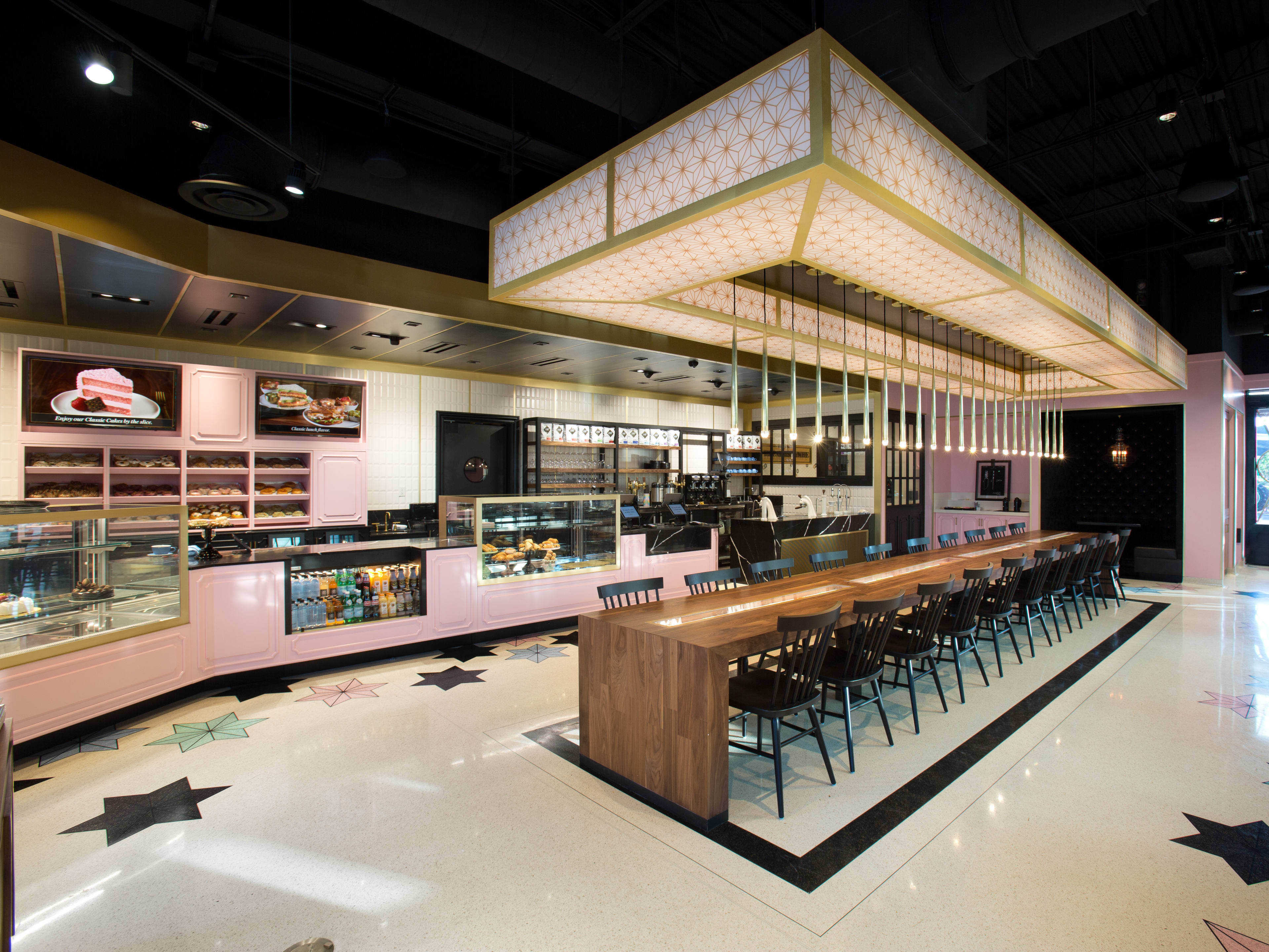 The Glass Knife interiors with a long wooden communal table and a view of their baked goods behind the counter