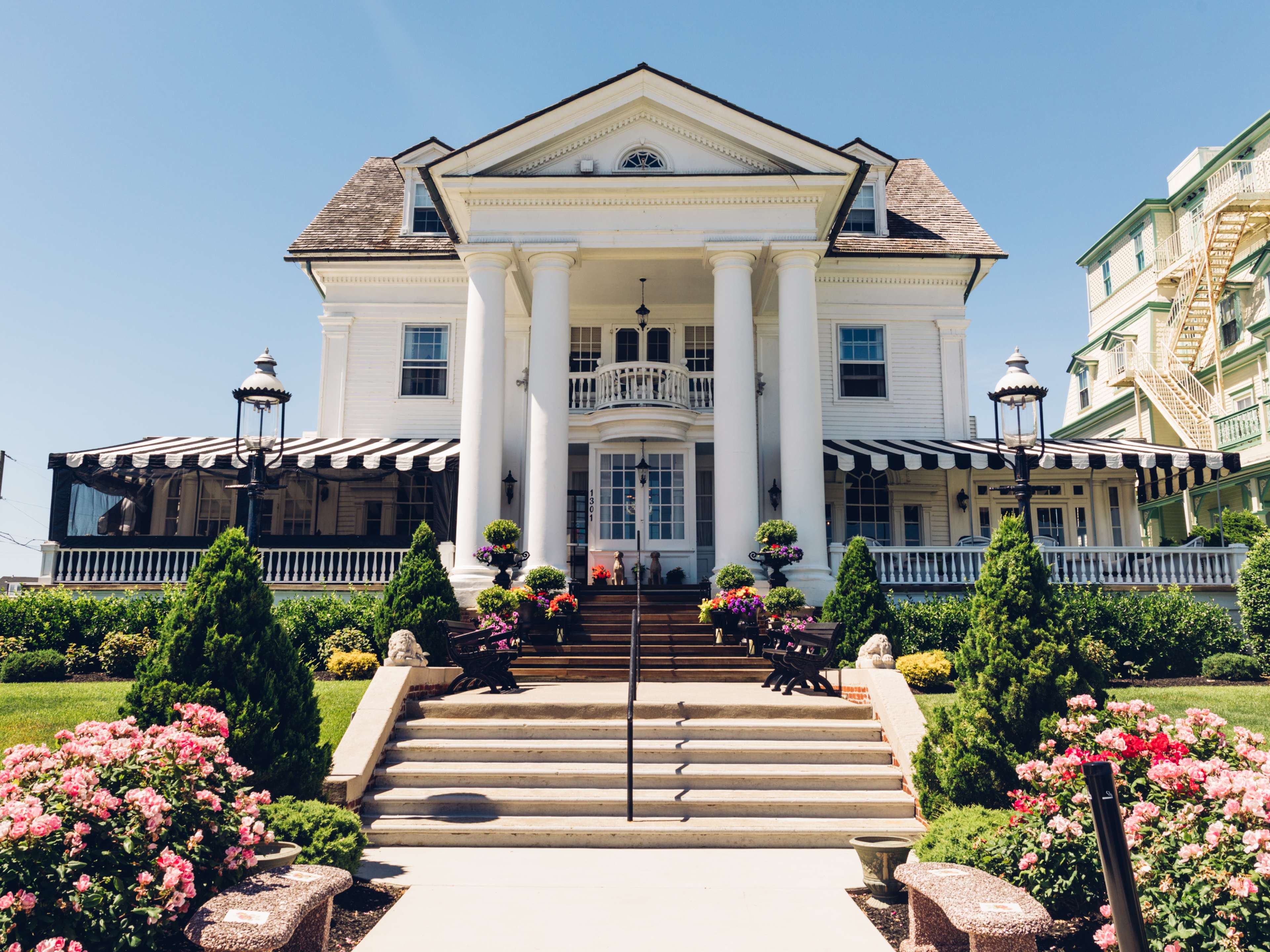 big formal restaurant with columns, front steps, and a garden