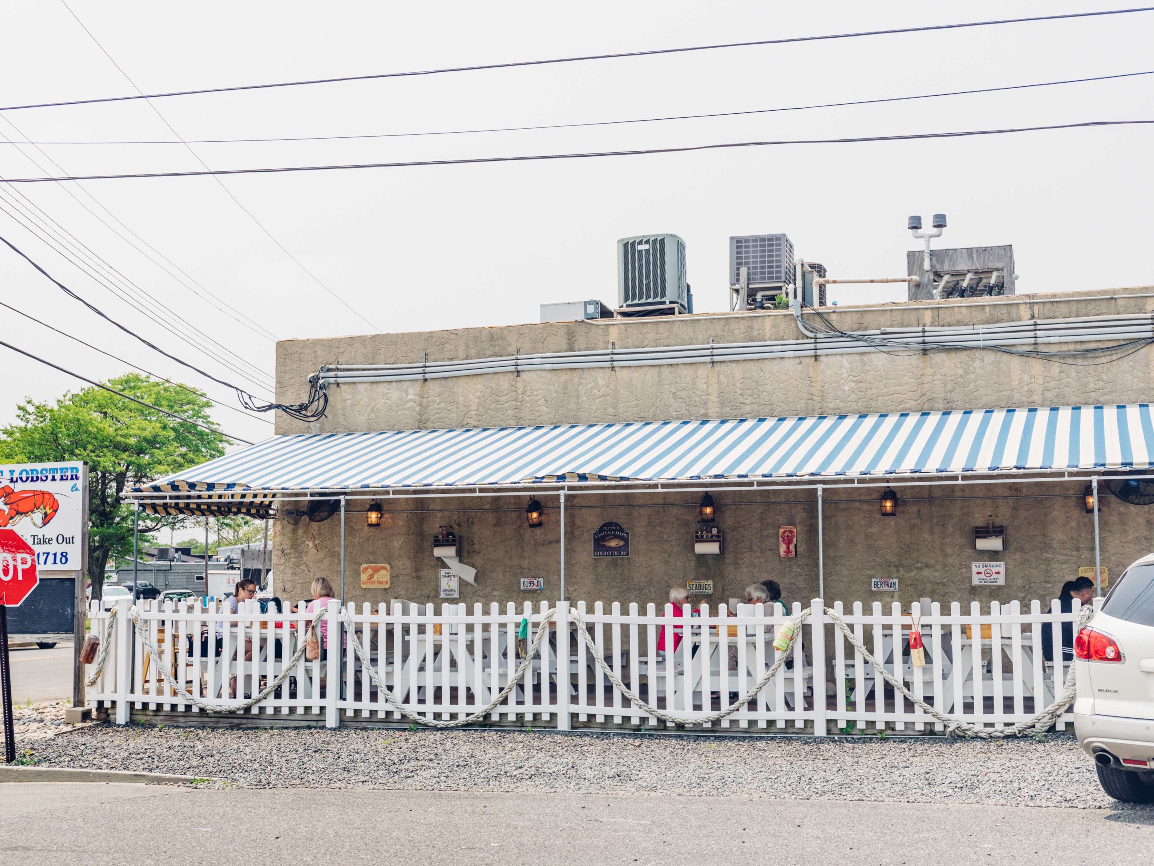 Point Lobster Co. exterior with outdoor seating fenced in on the side of the building