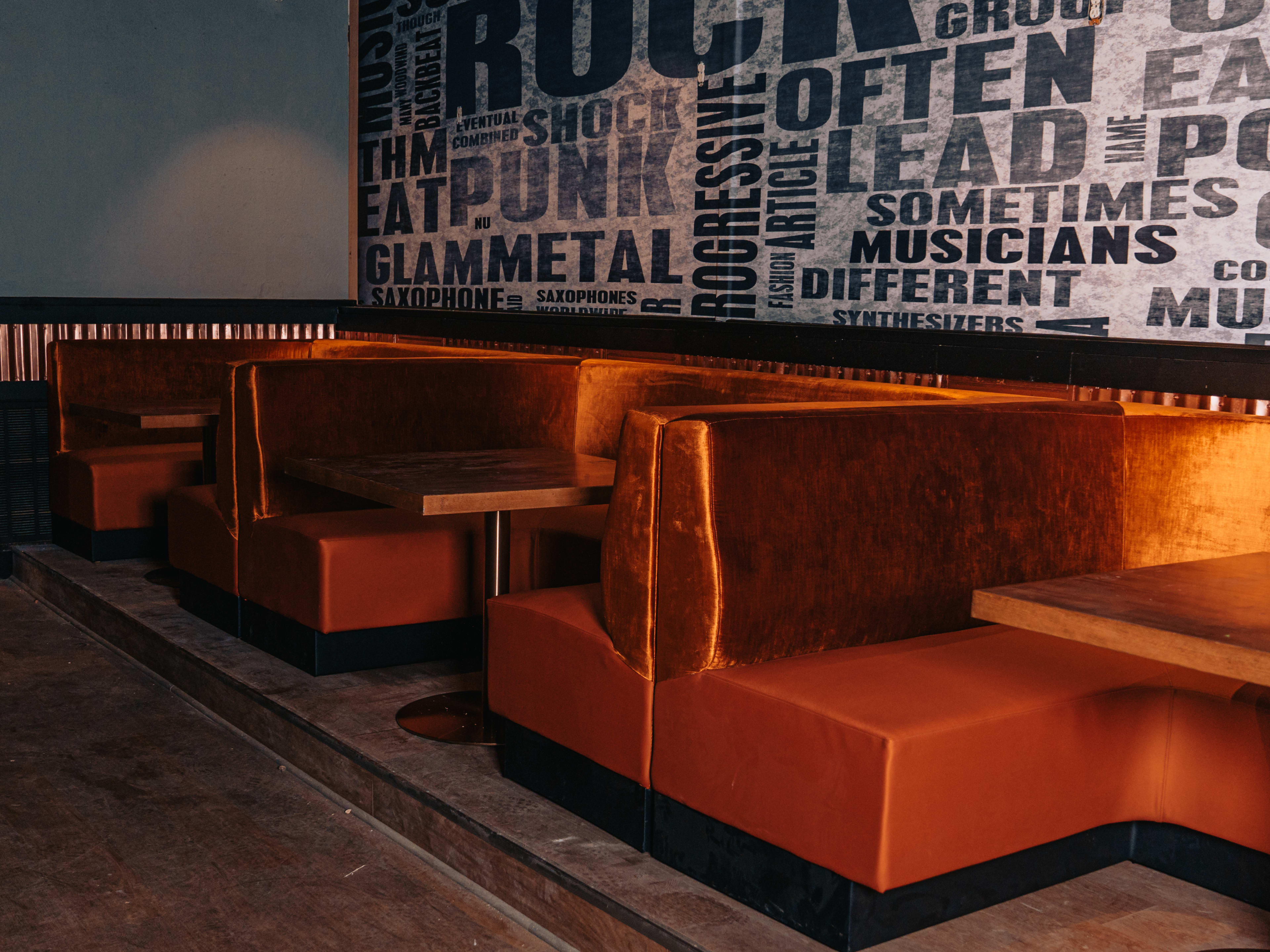 Rockhouse Southern Kitchen interiors with orange booth seating and text graphic wallpaper