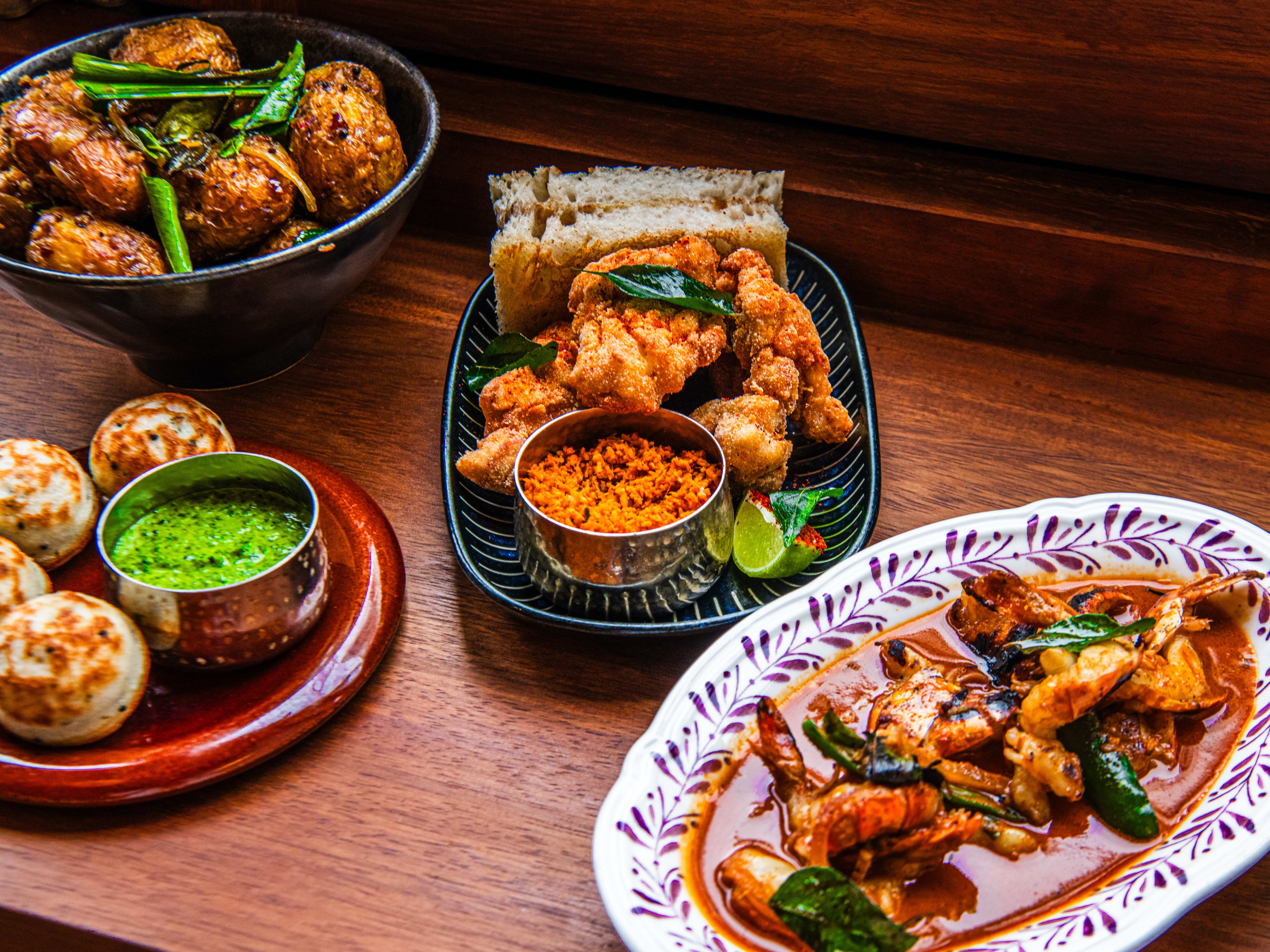 A spread of dishes from Rambutan on a wooden table.