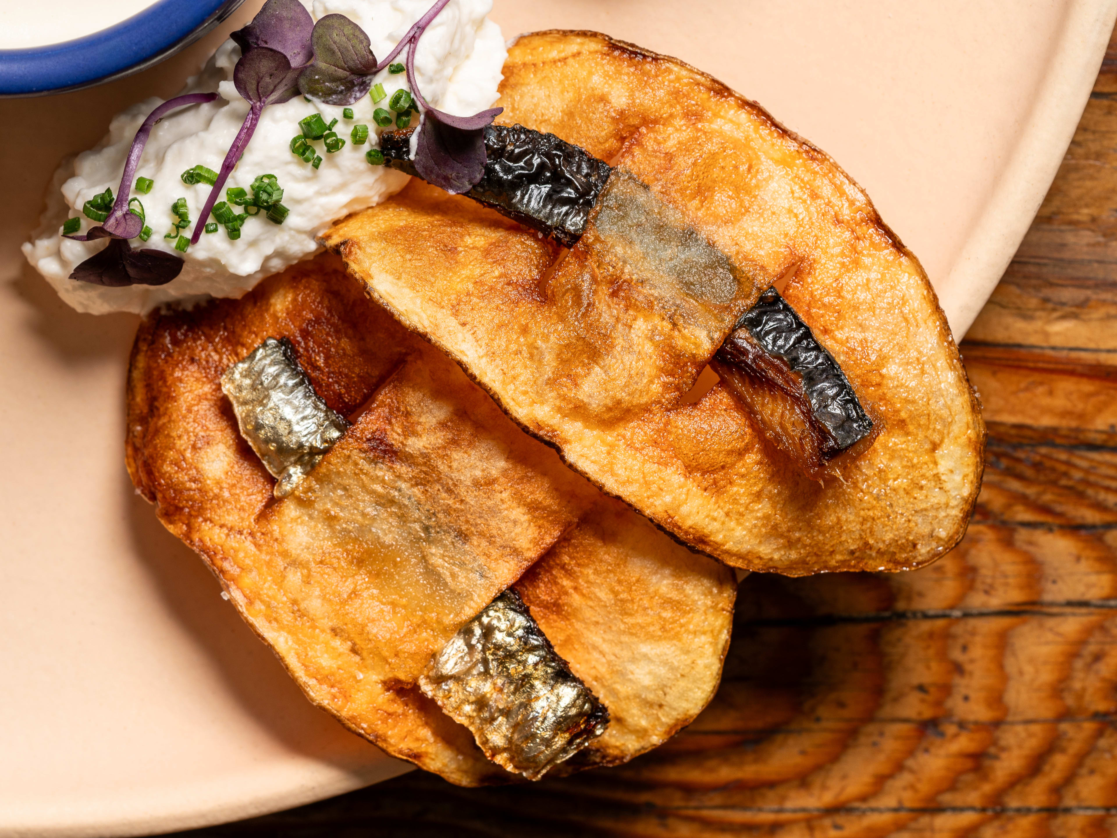 The chip with a whole sardine slotted through at Rich Table