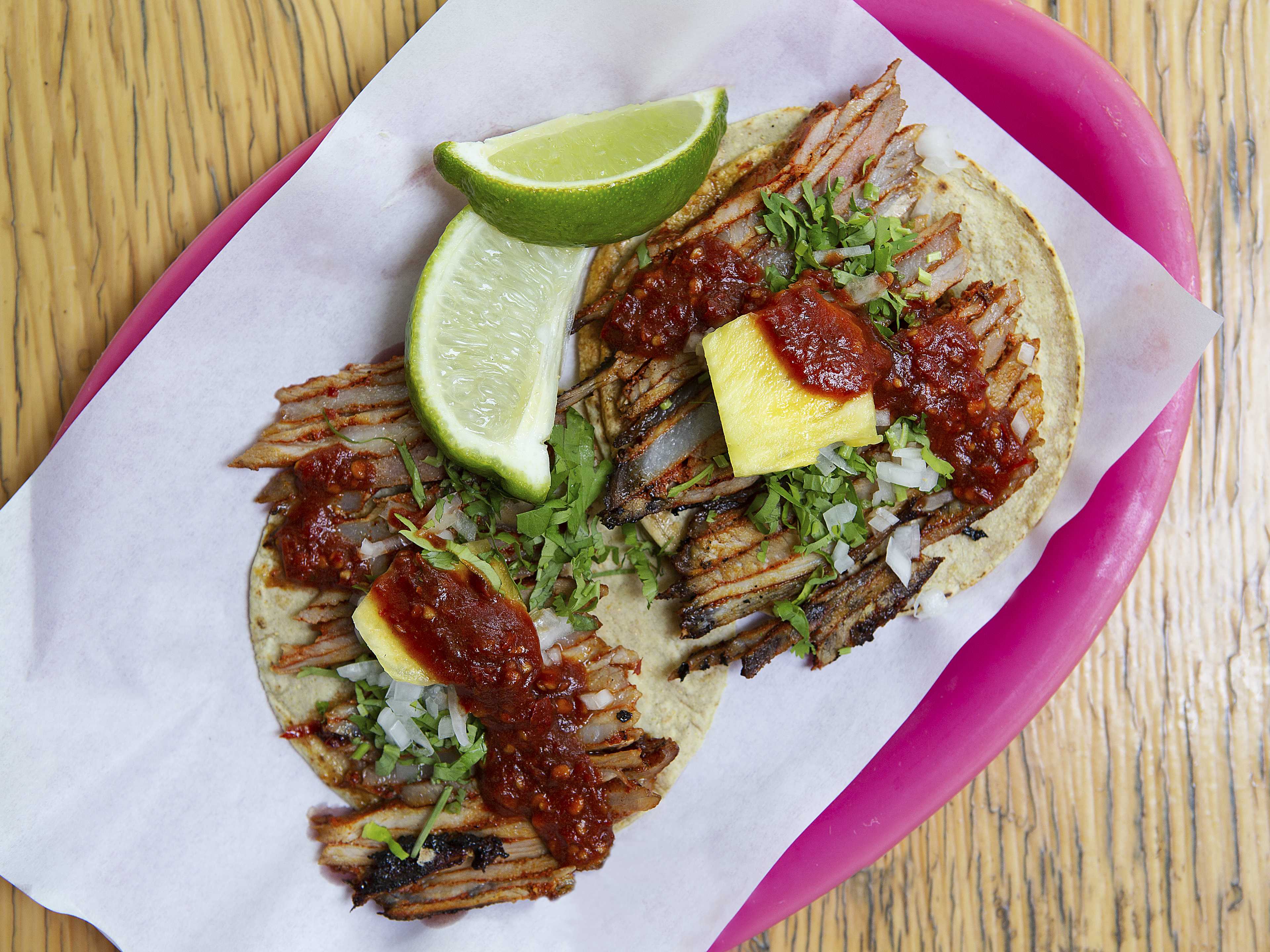 Al pastor tacos topped with salsa and pineapple at Taqueria El Oso