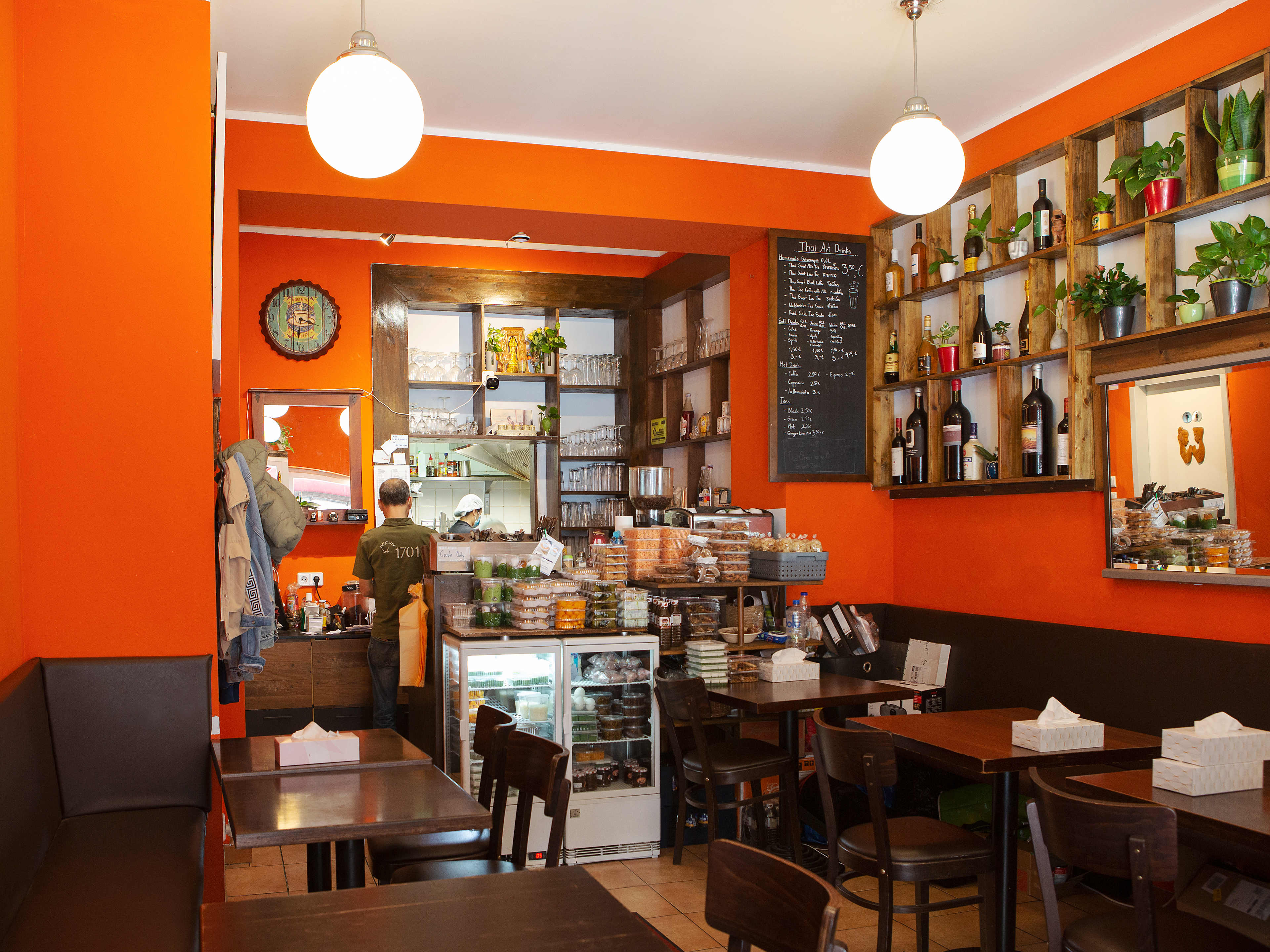 Interior dining space at Thai-ARt with bright orange walls