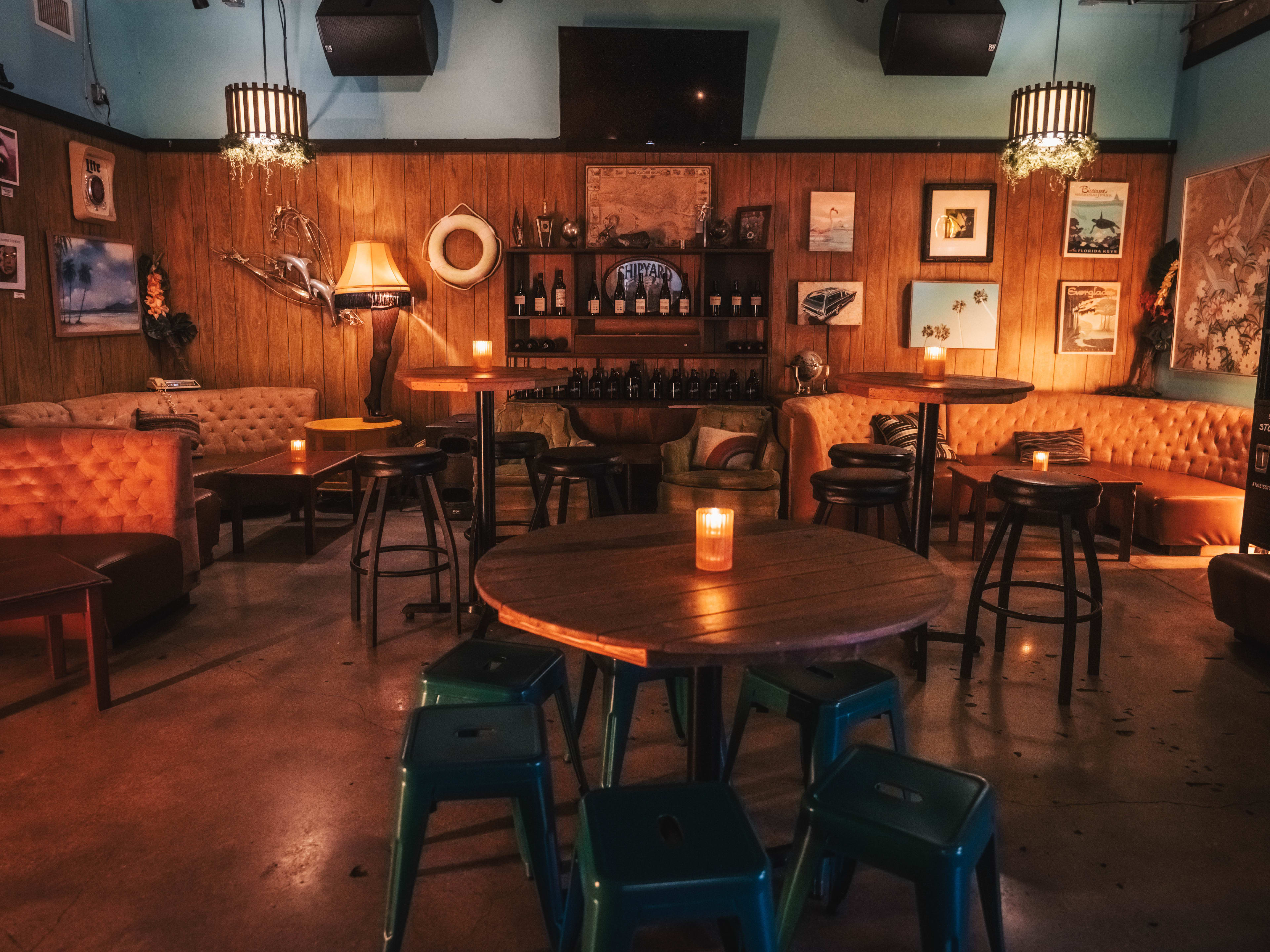 A bar with wooden walls, tables, and booths.