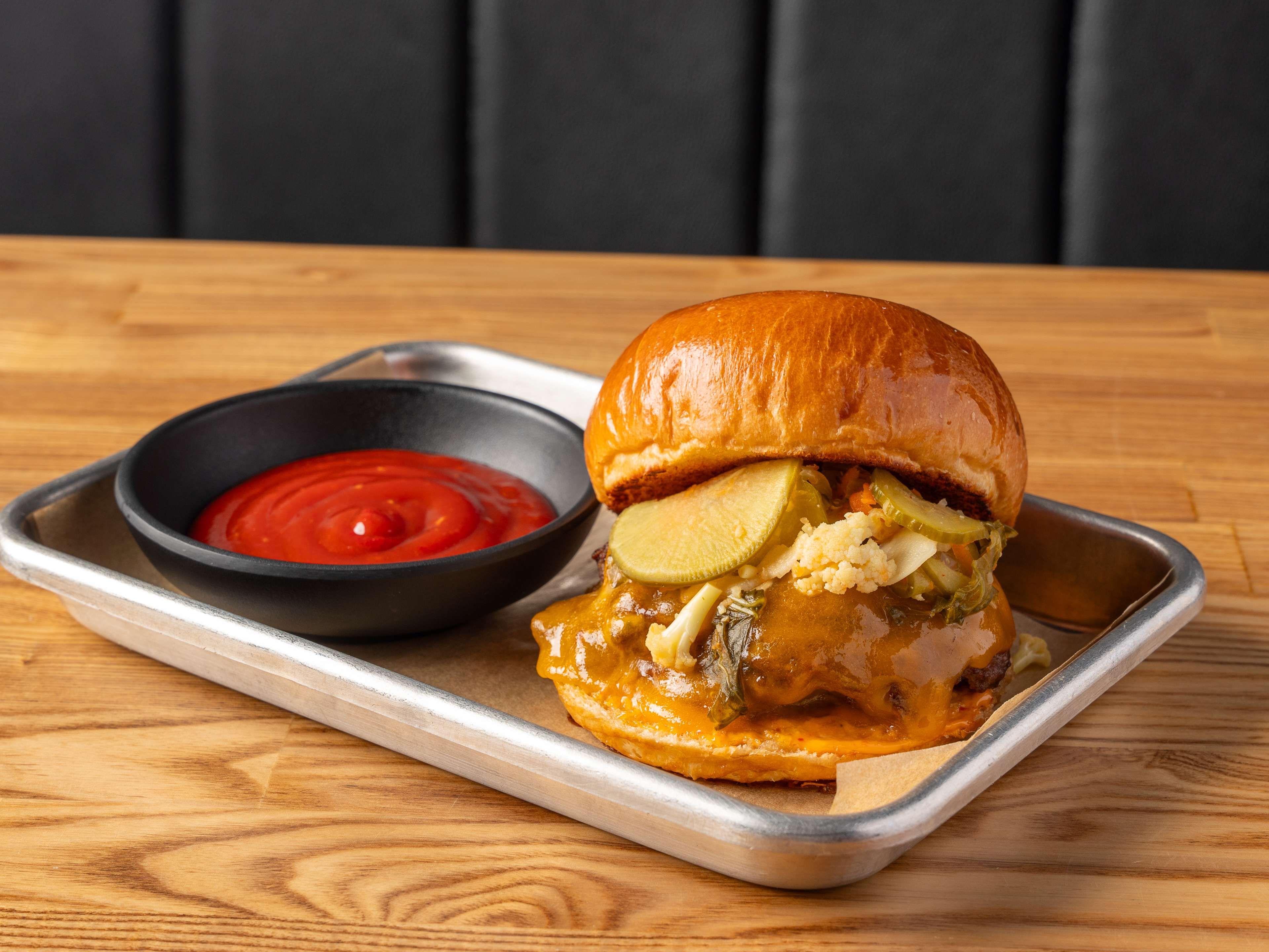 A smash burger served with a side of gochujang ketchup.