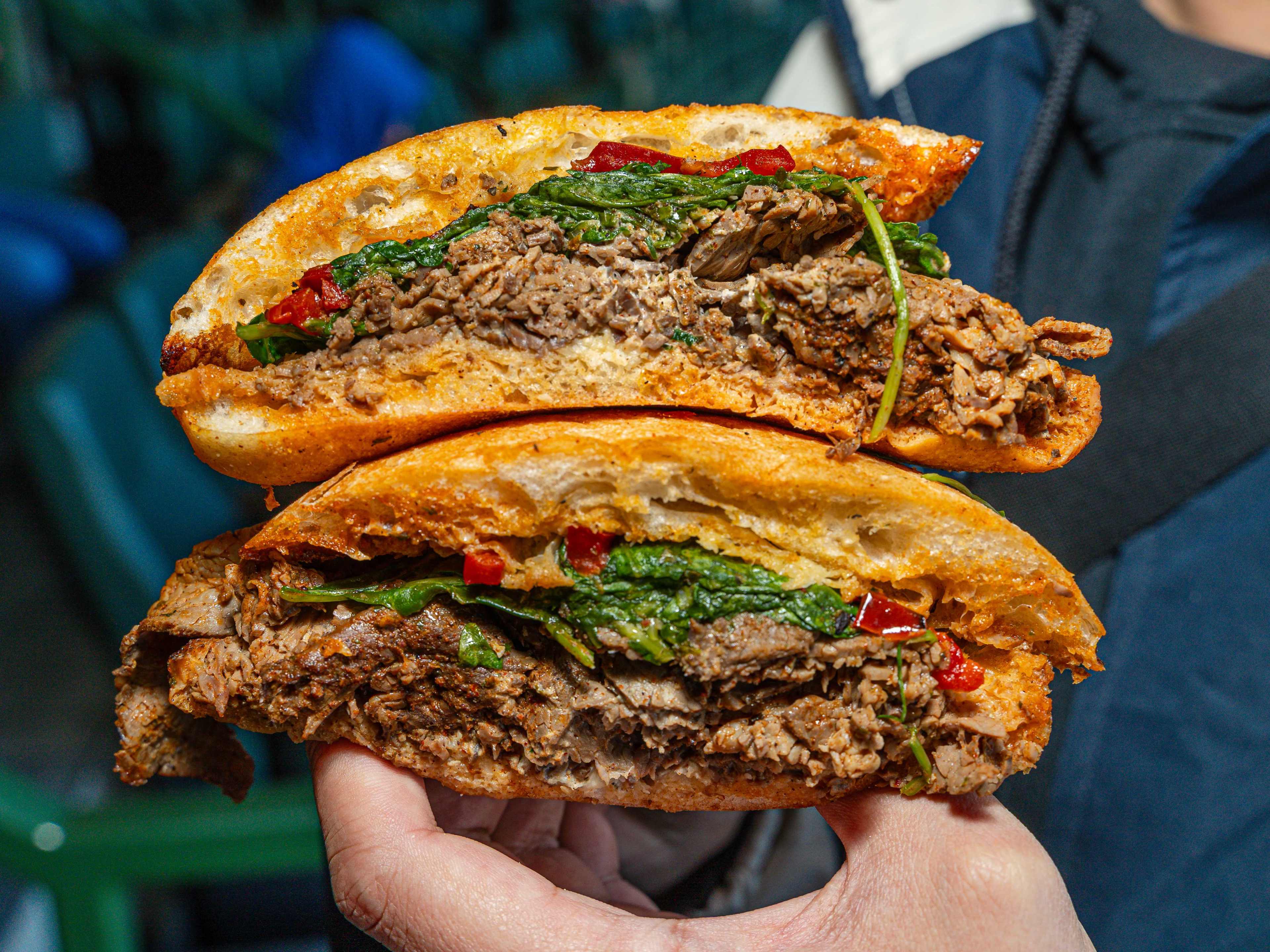 Two pieces of a chimichurri steak sandwich stacked on top of each other.