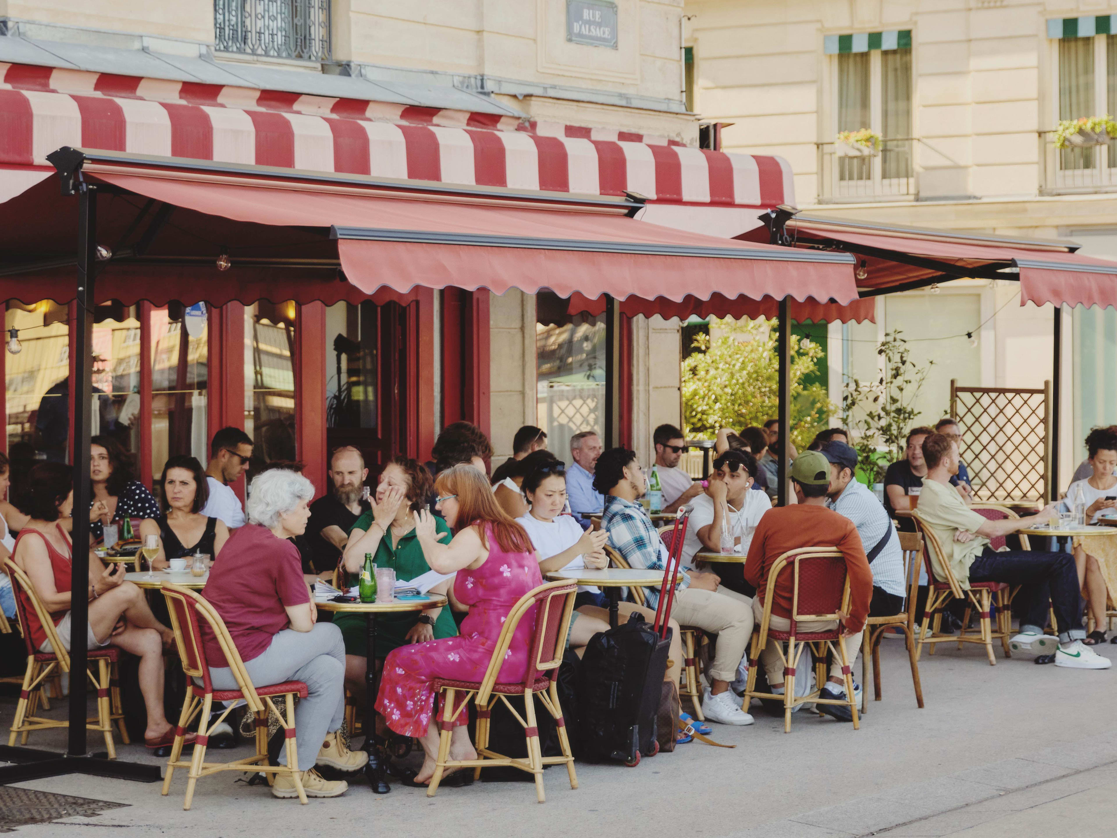 Outdoor dining space during busy lunch service at Cafe Les Deux Gares