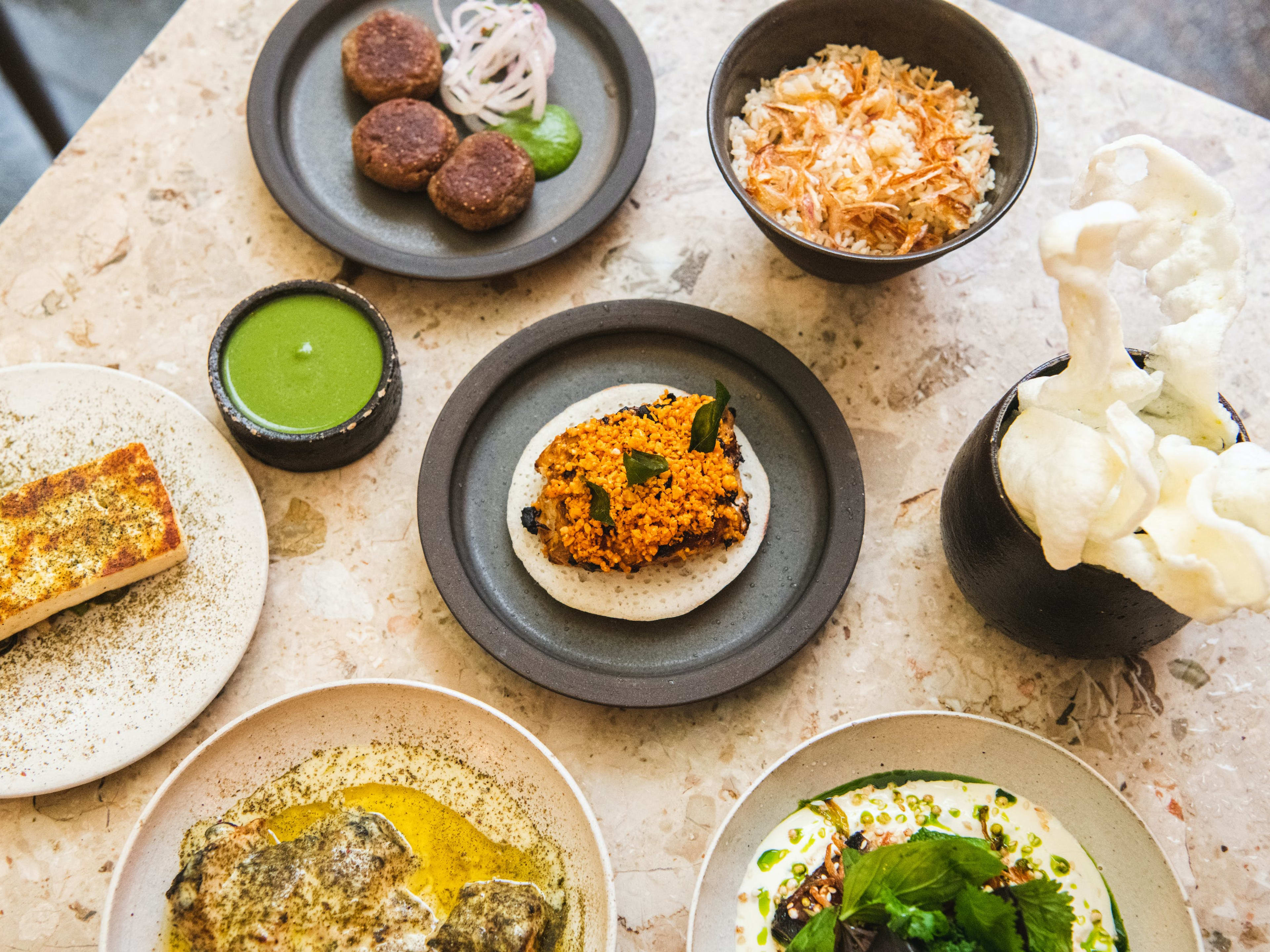 A spread of dishes from Bibi on a marble table.