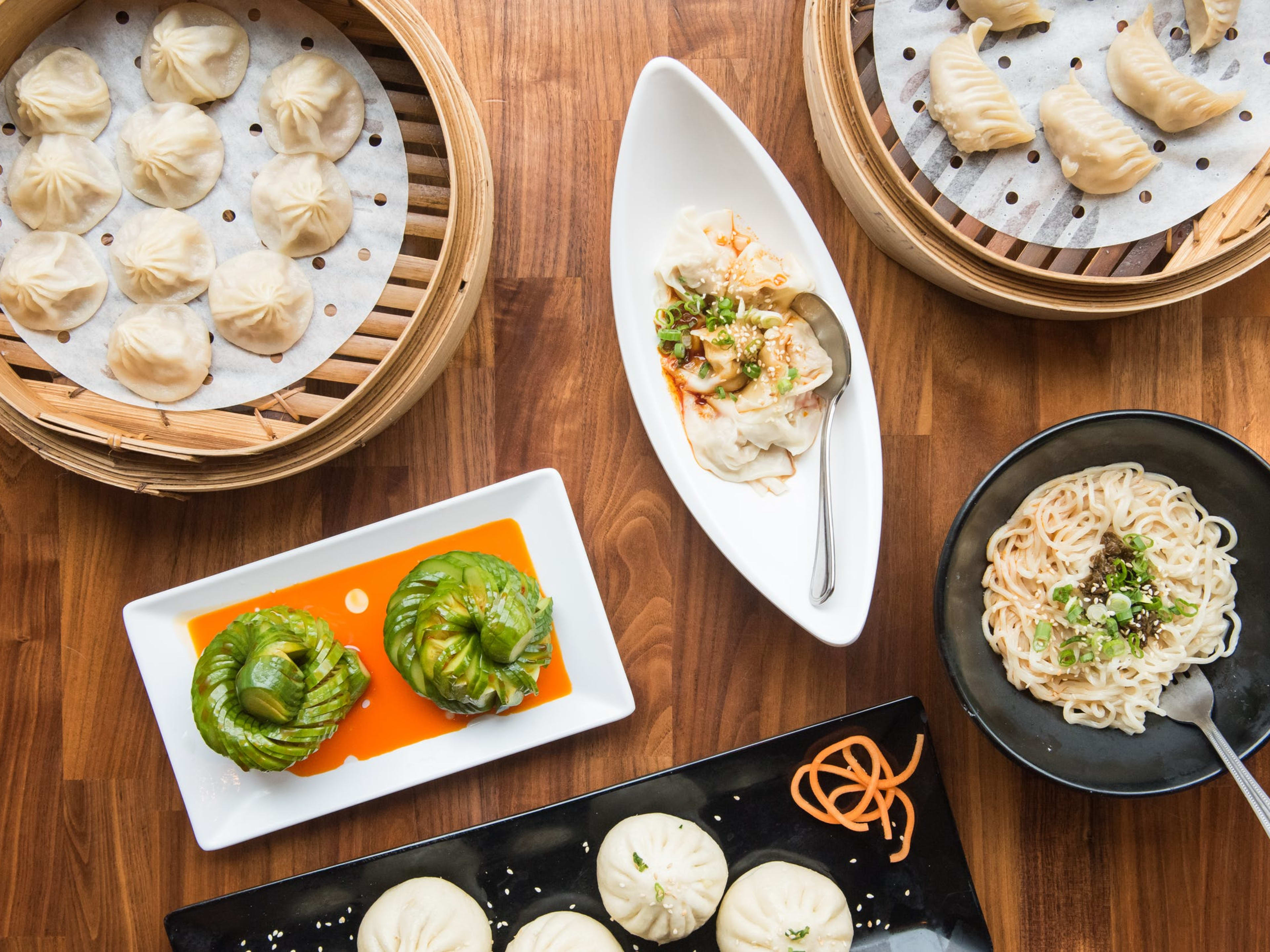 Assortment of dumplings, noodles, and cucumber salad