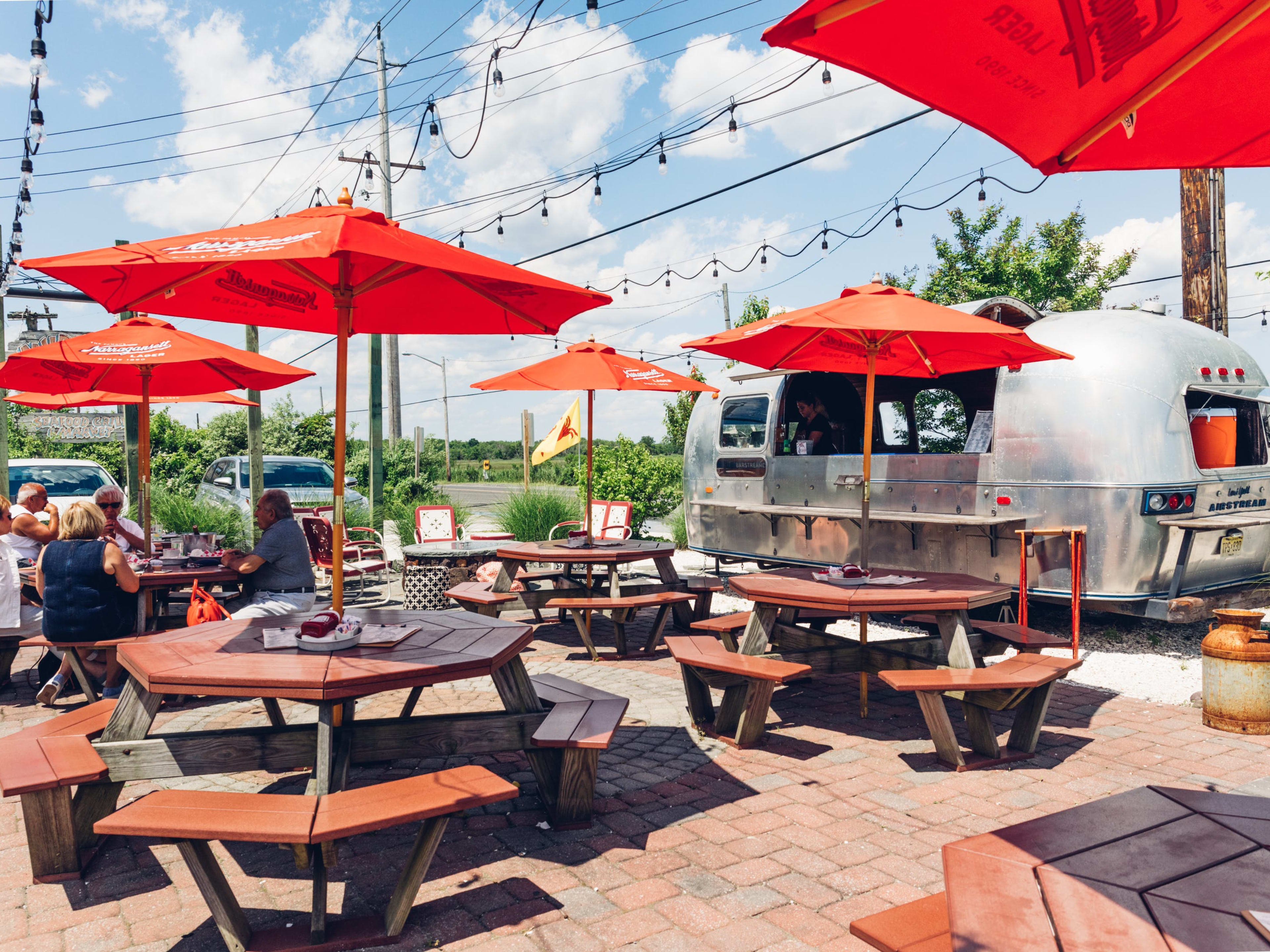 Mud city crab house exteriors with picnic tables and an airstream to order food at