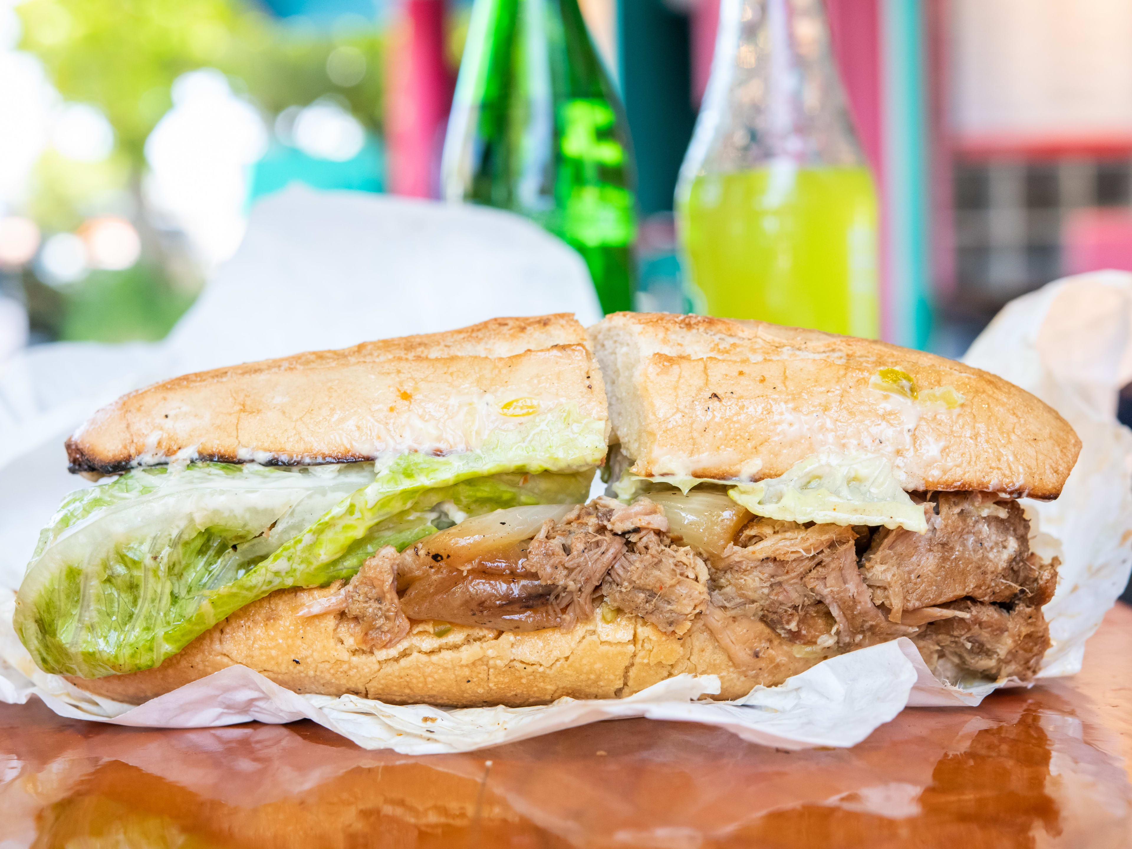 baguette sandwich filled with Caribbean roast pork, romaine lettuce, and grilled onions.