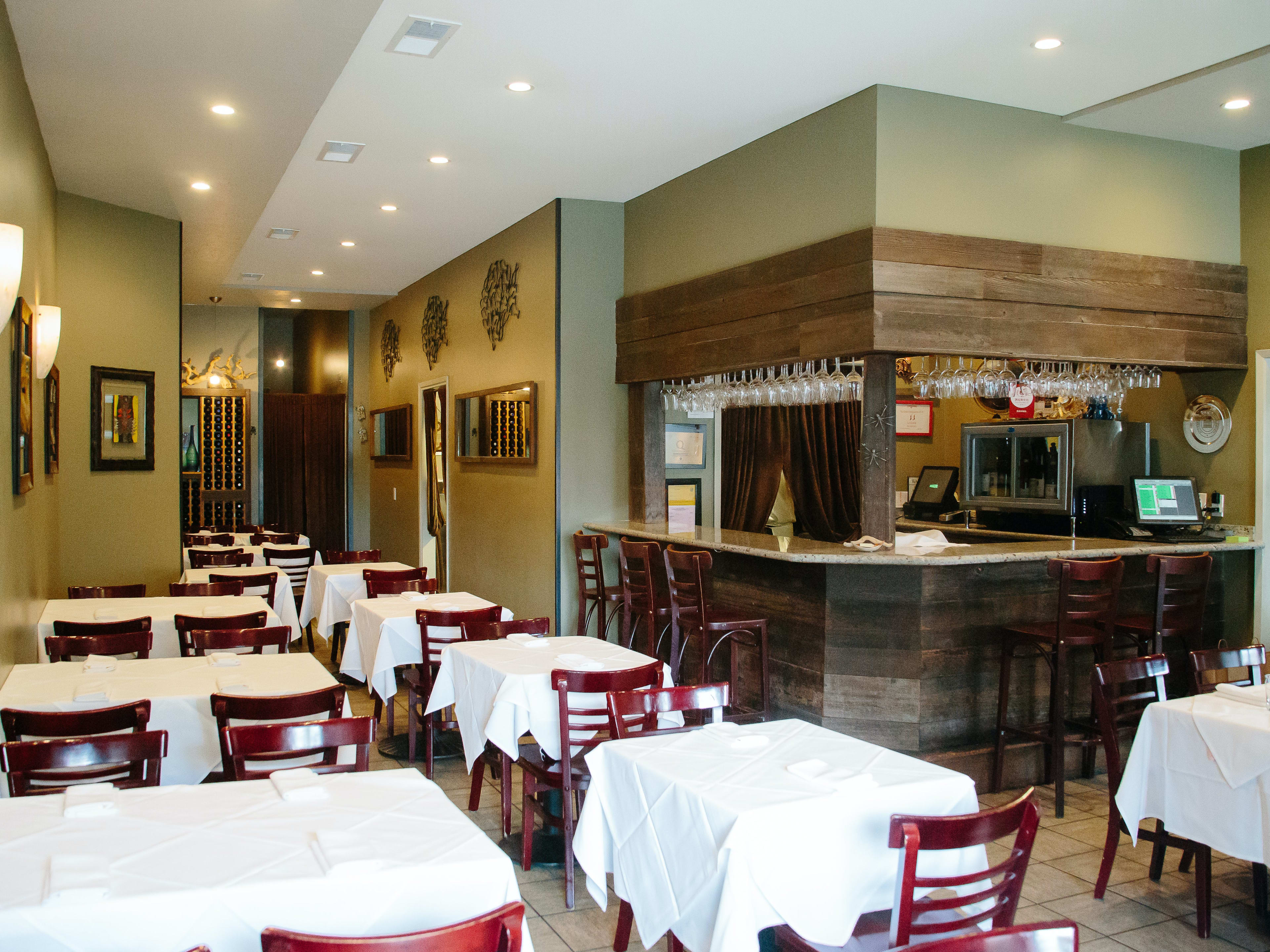 interior of restaurant with tables that have tablecloths on them