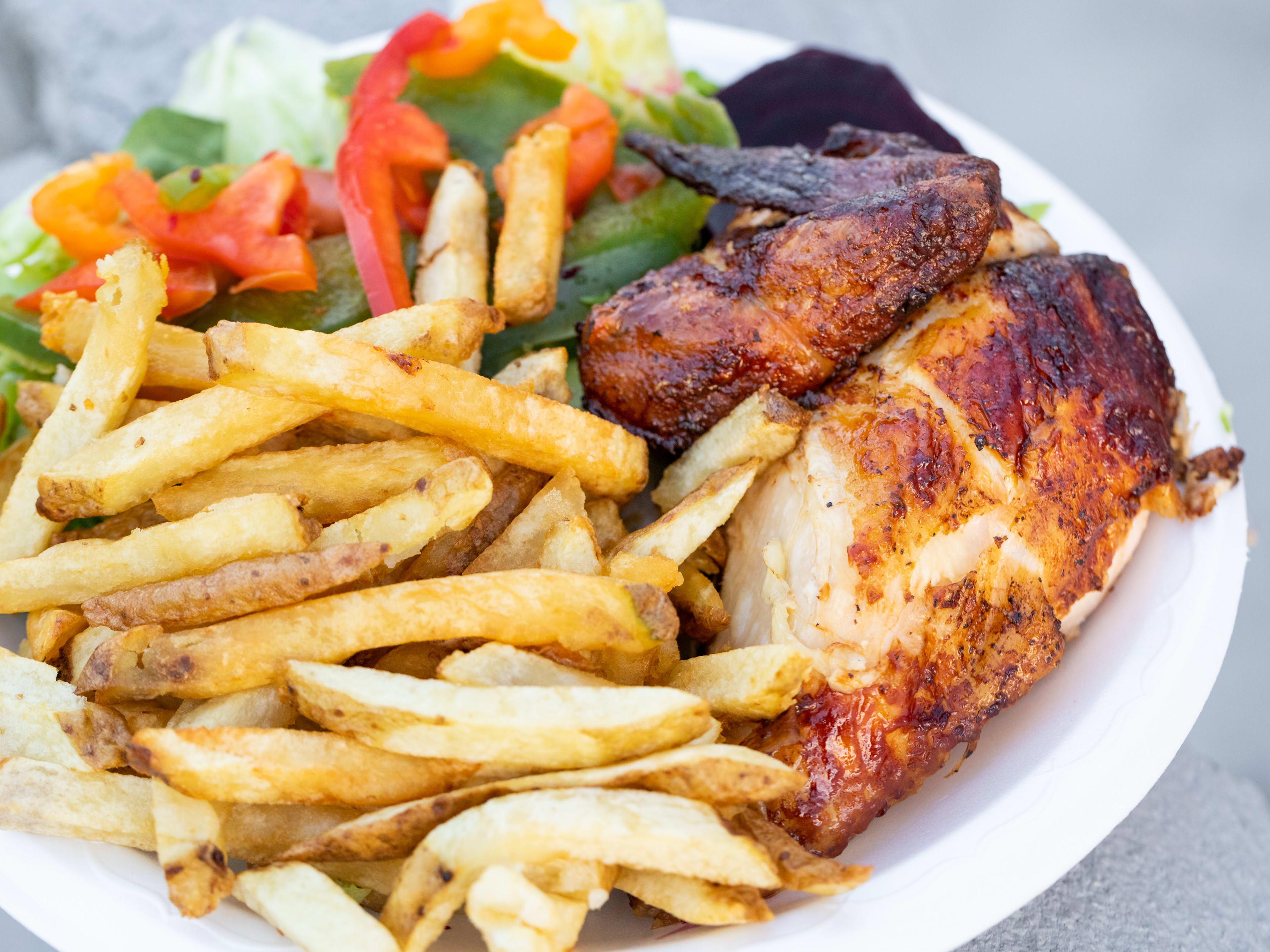 The rotisserie chicken from Pollo A La Brasa served with salad and fries.