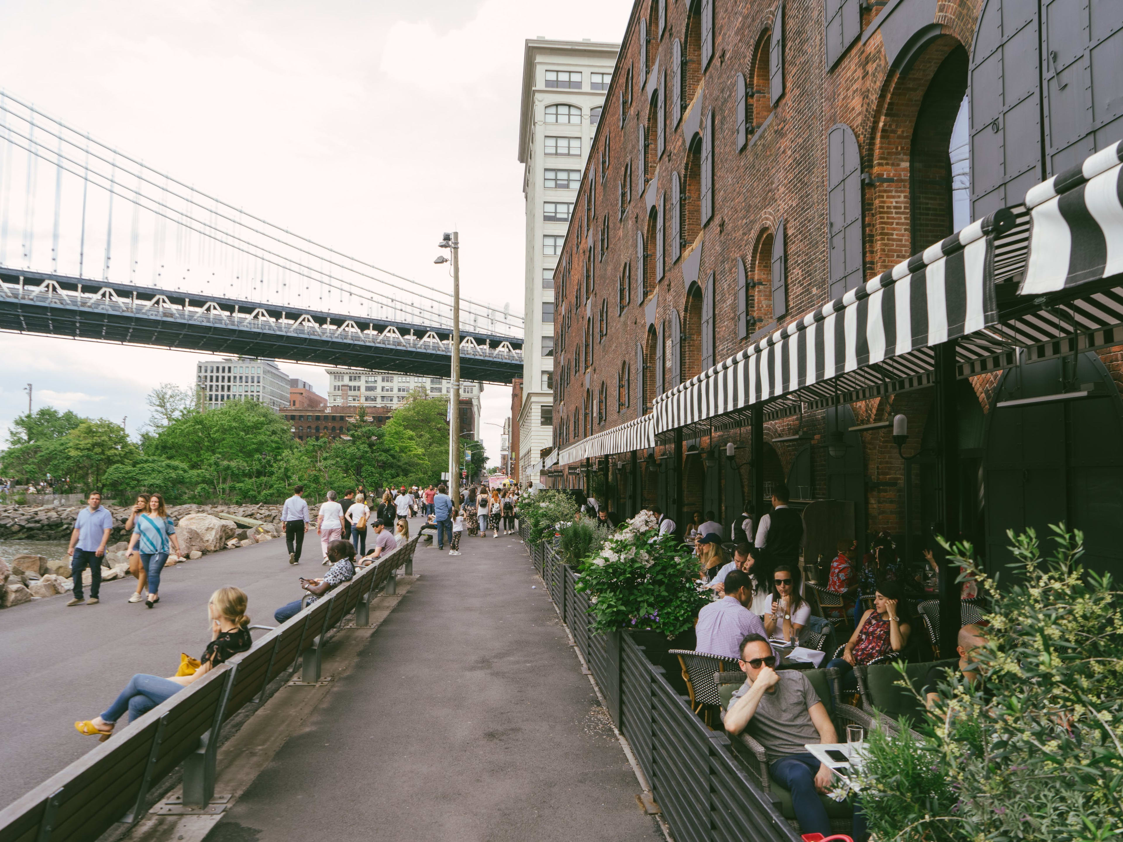 The outdoor seating at Cecconi's Dumbo with a view of the bridge and the water.