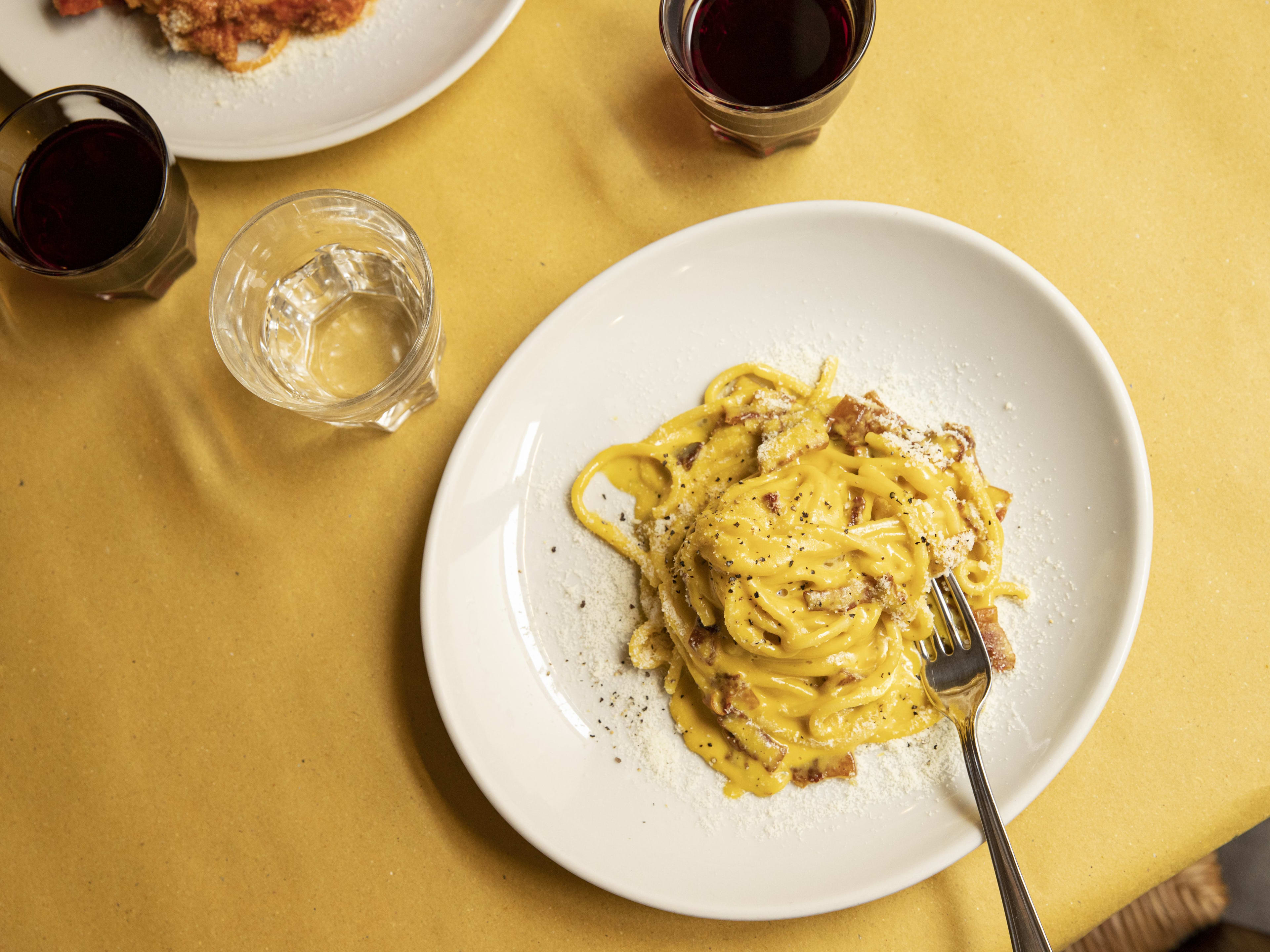 Spaghetti carbonara on white ceramic plate at Piatto Romano