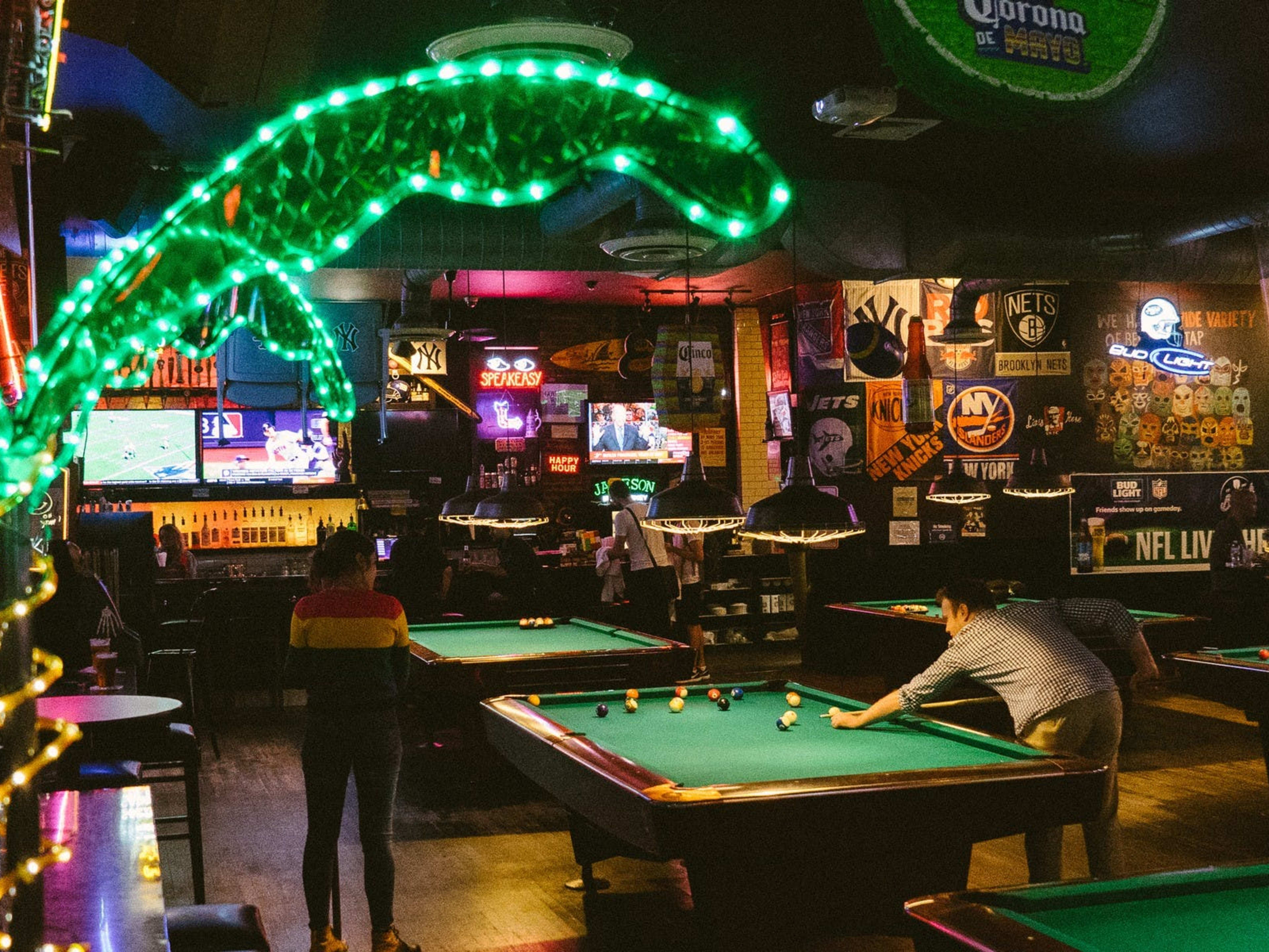 A dark pool hall with a light-up palm tree.