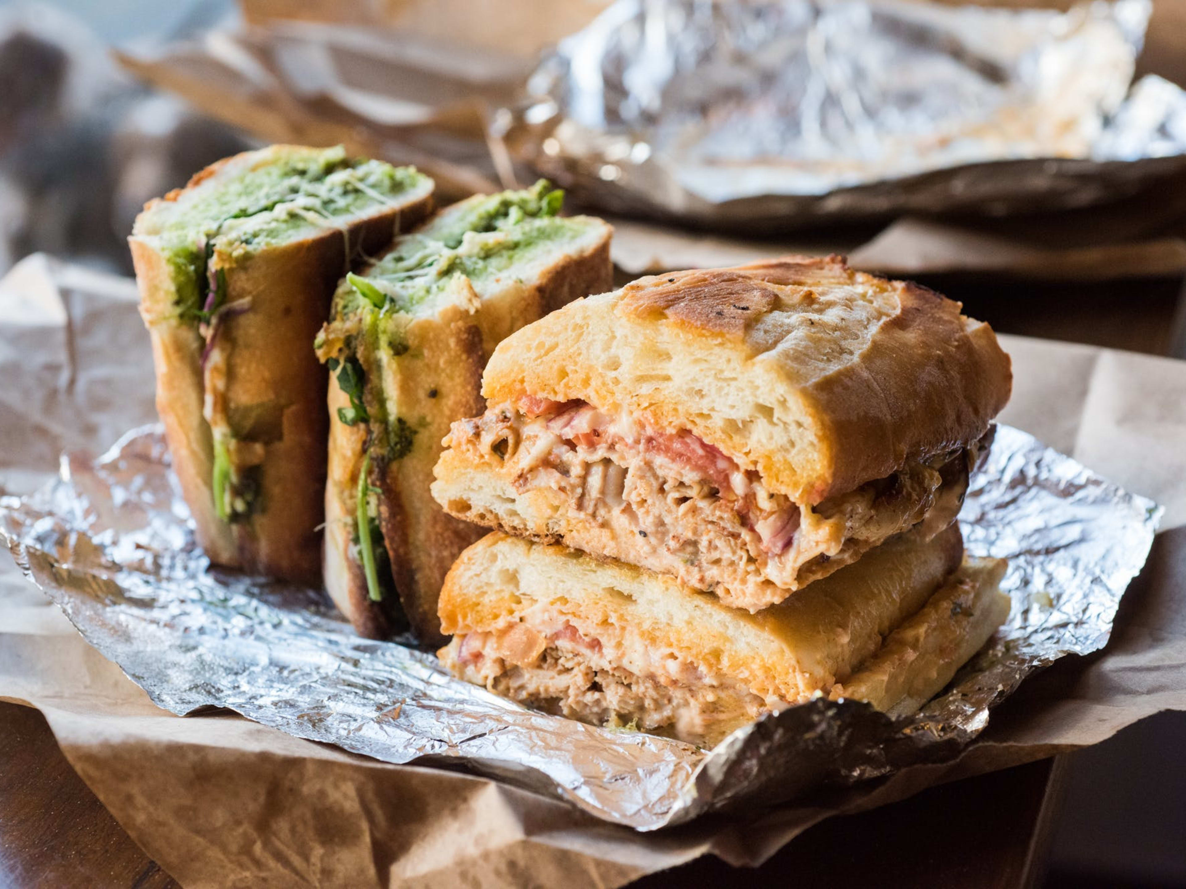 Sandwiches laid on top of aluminum foil.