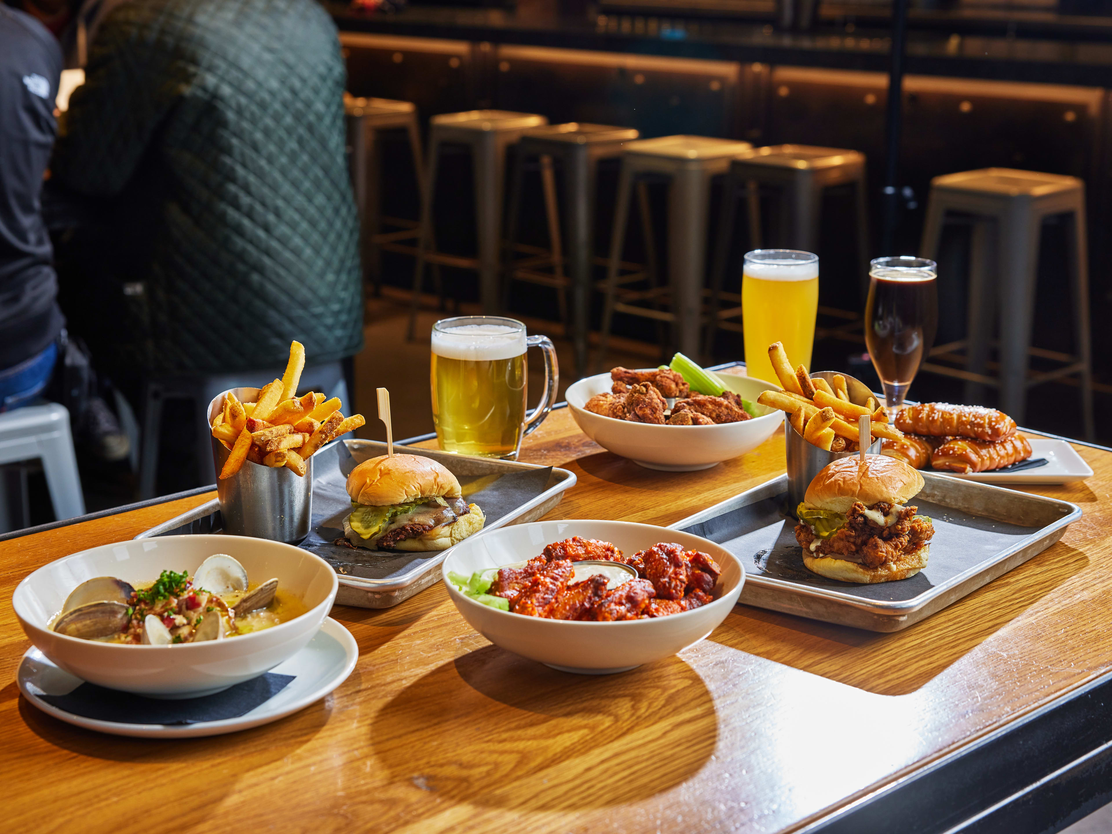 Spread of dishes and draught beers on wooden table at Trillium Brewing