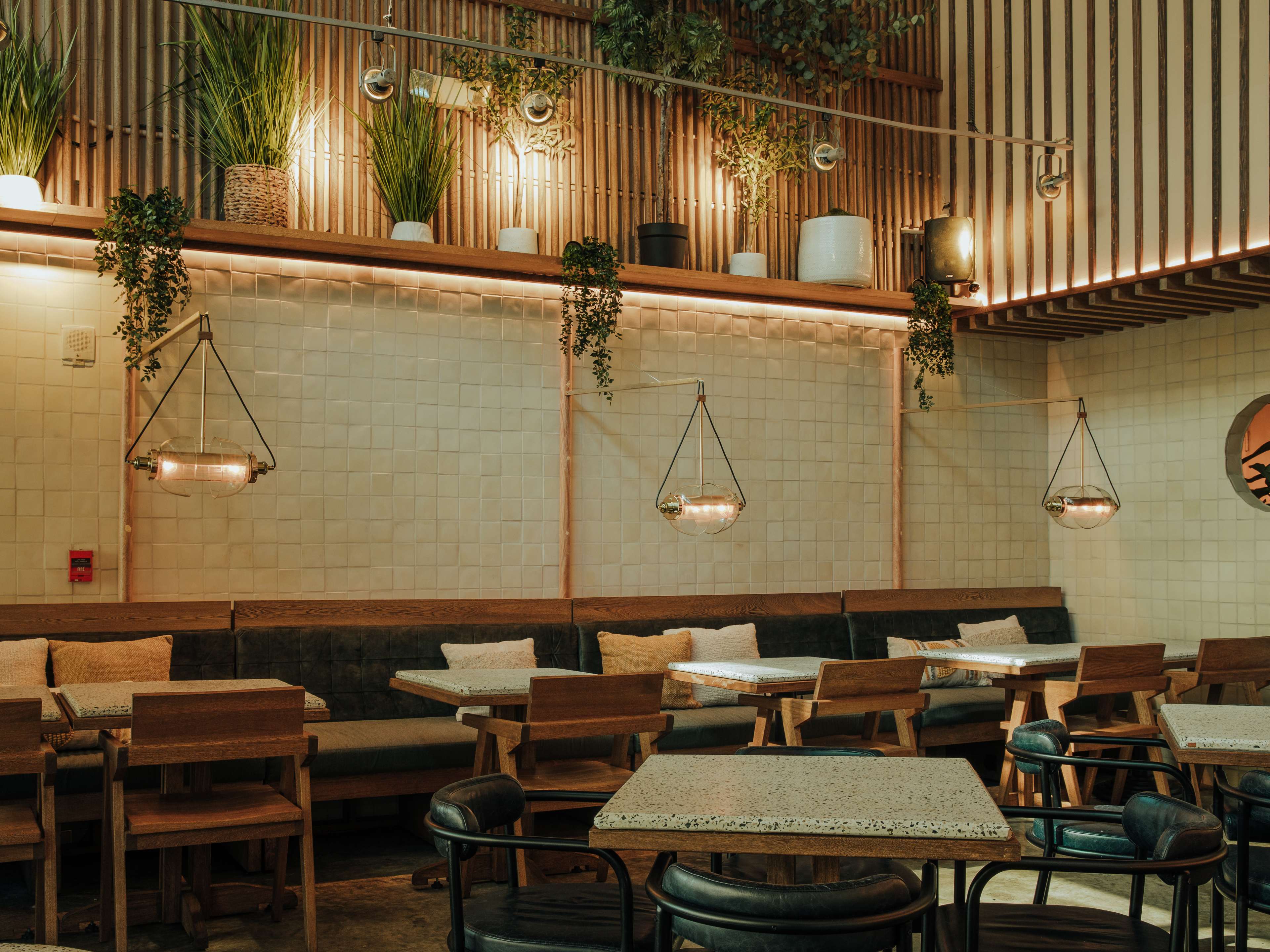 brick walled restaurant interior with low lighting and lots of plants