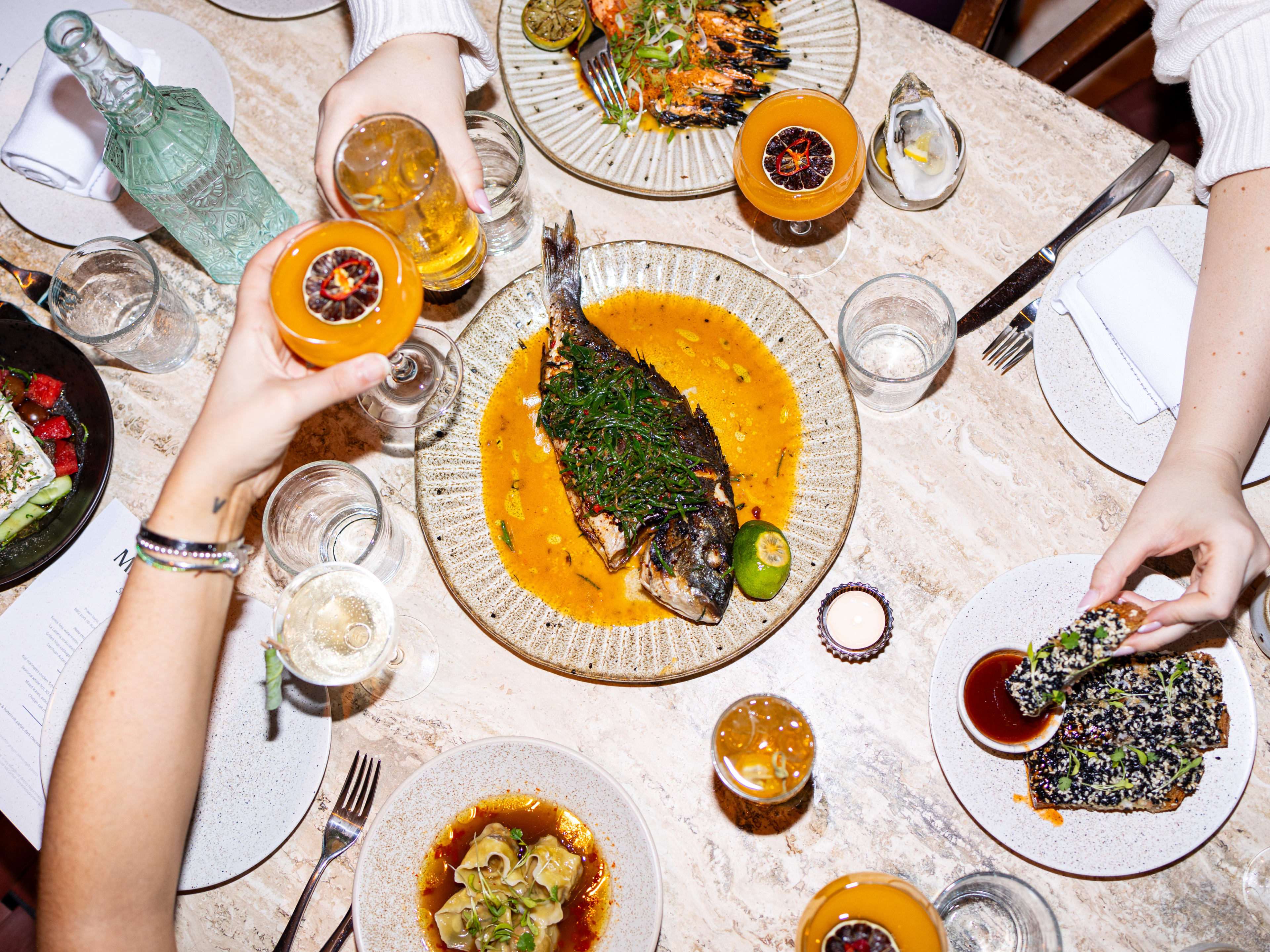 A food spread at Milk Beach in Soho, including a grilled fish dish.