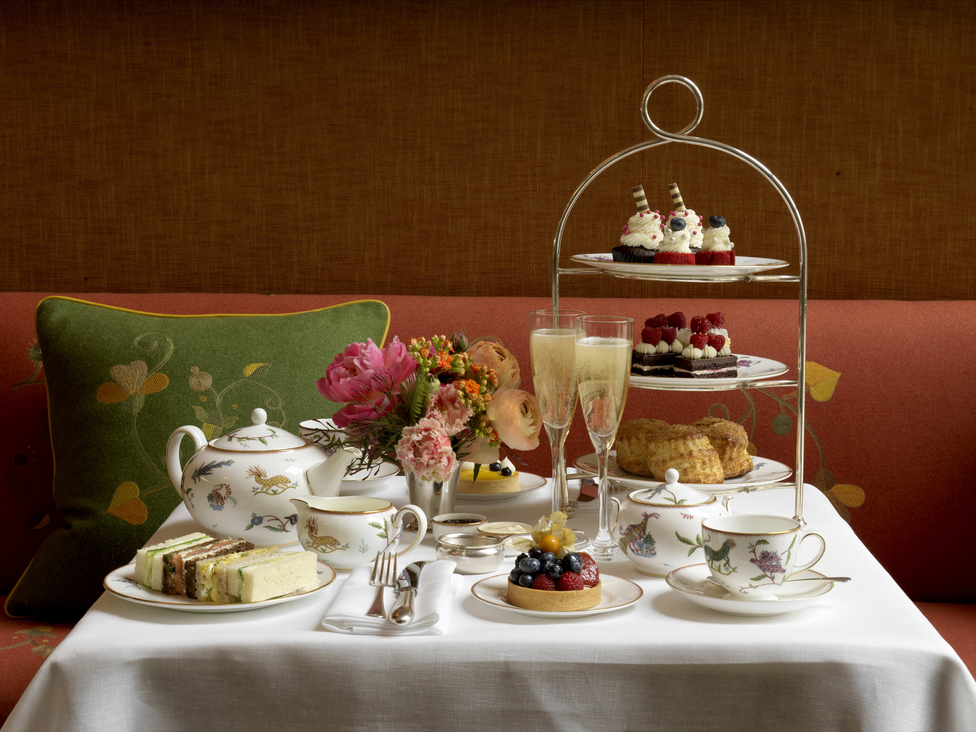 An elaborate afternoon tea set on a table covered in a white tablecloth.