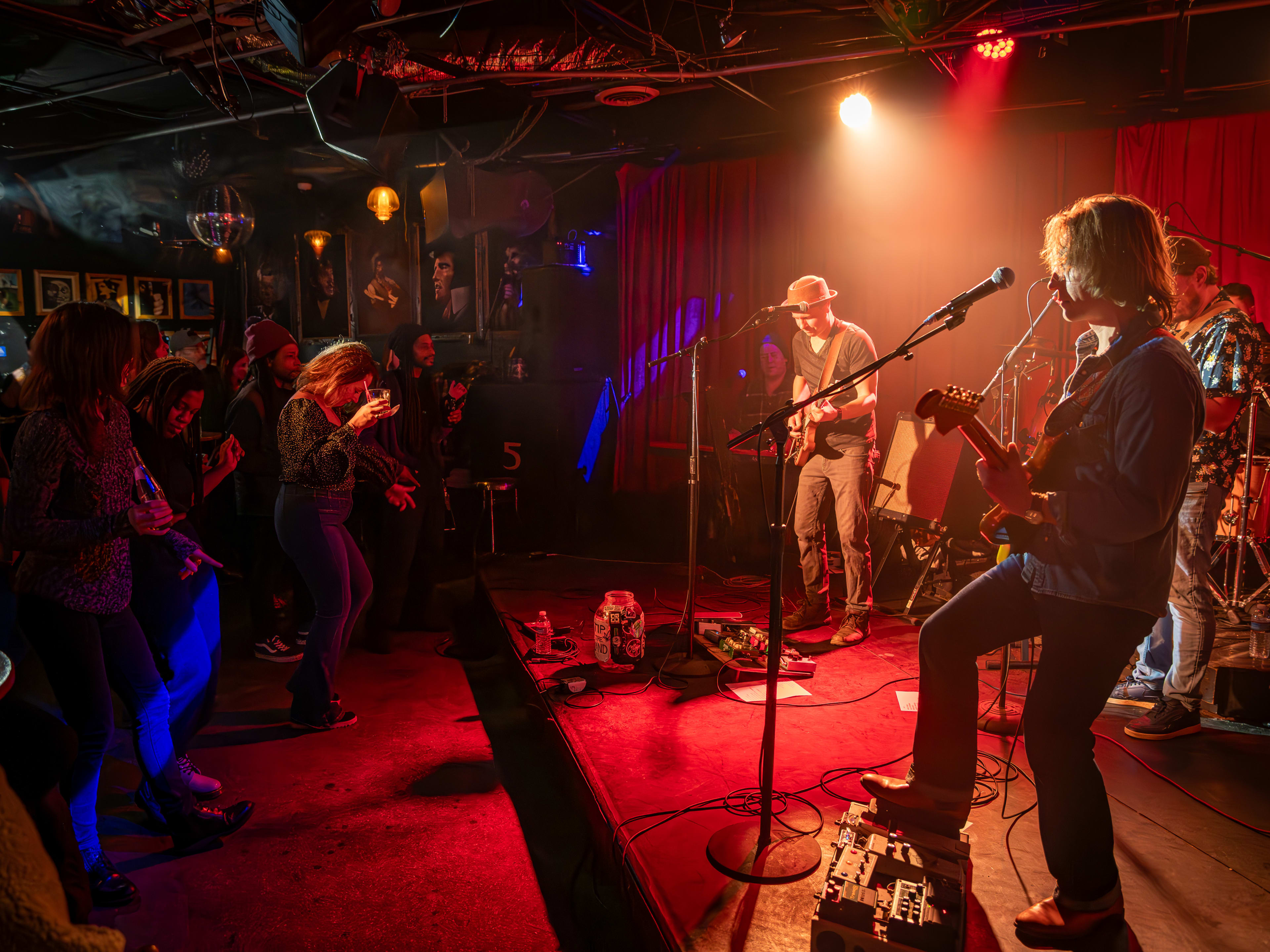 Band playing live set for audience on red stage at The 5 Spot