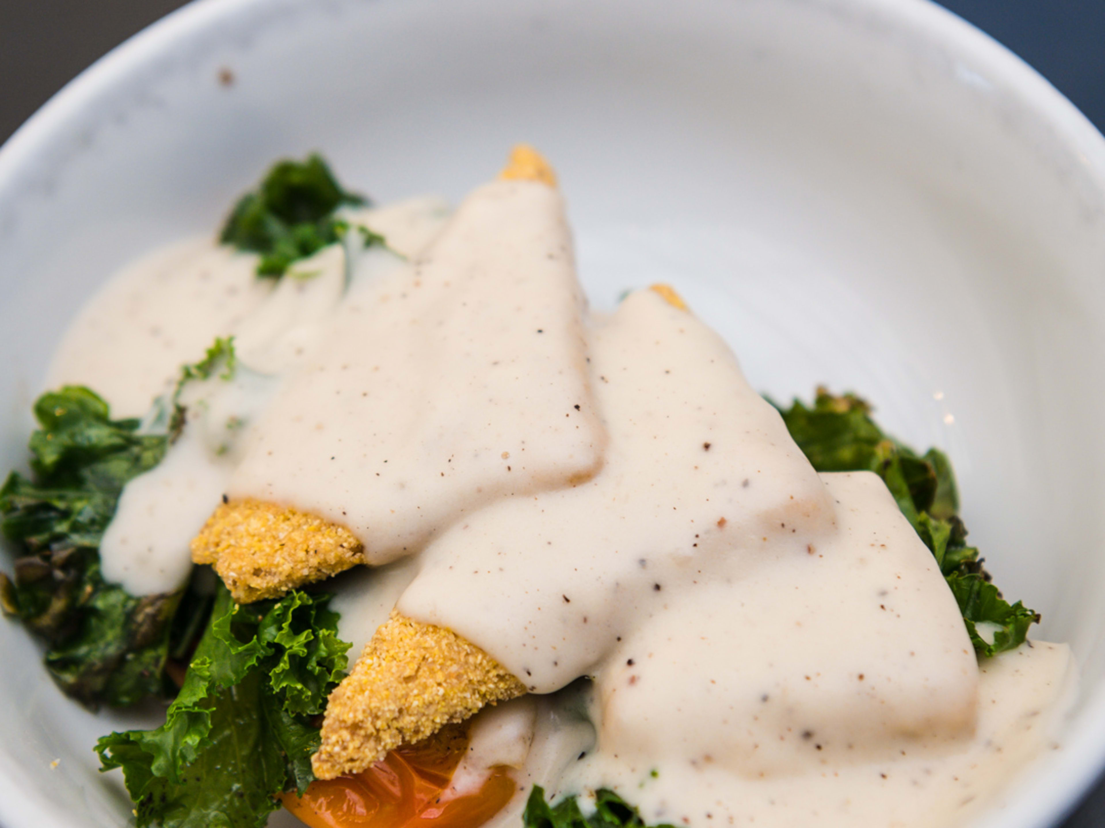 A bowl with greens and gravy.