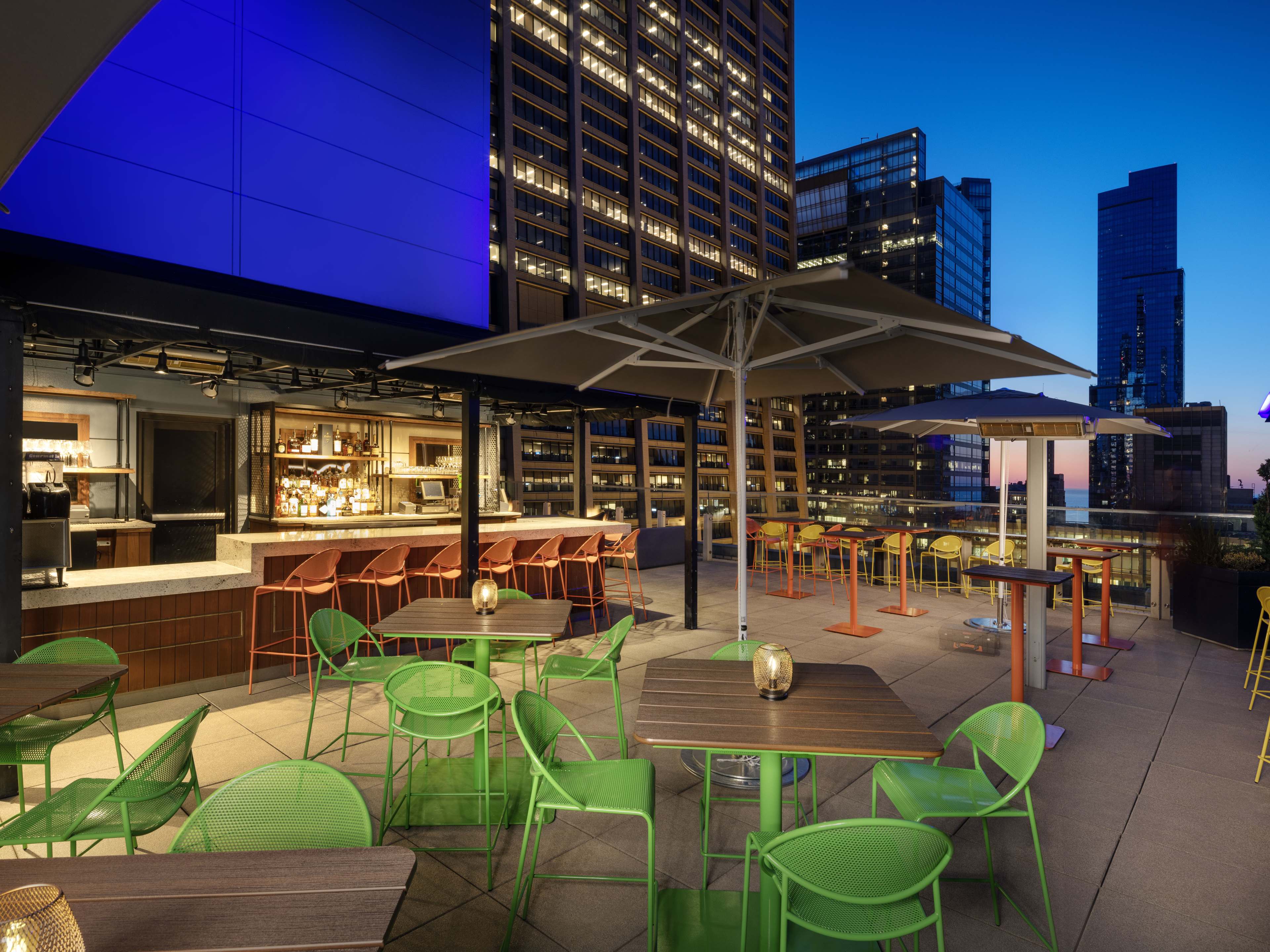 Rooftop patio with a small bar in one corner and lots of tables