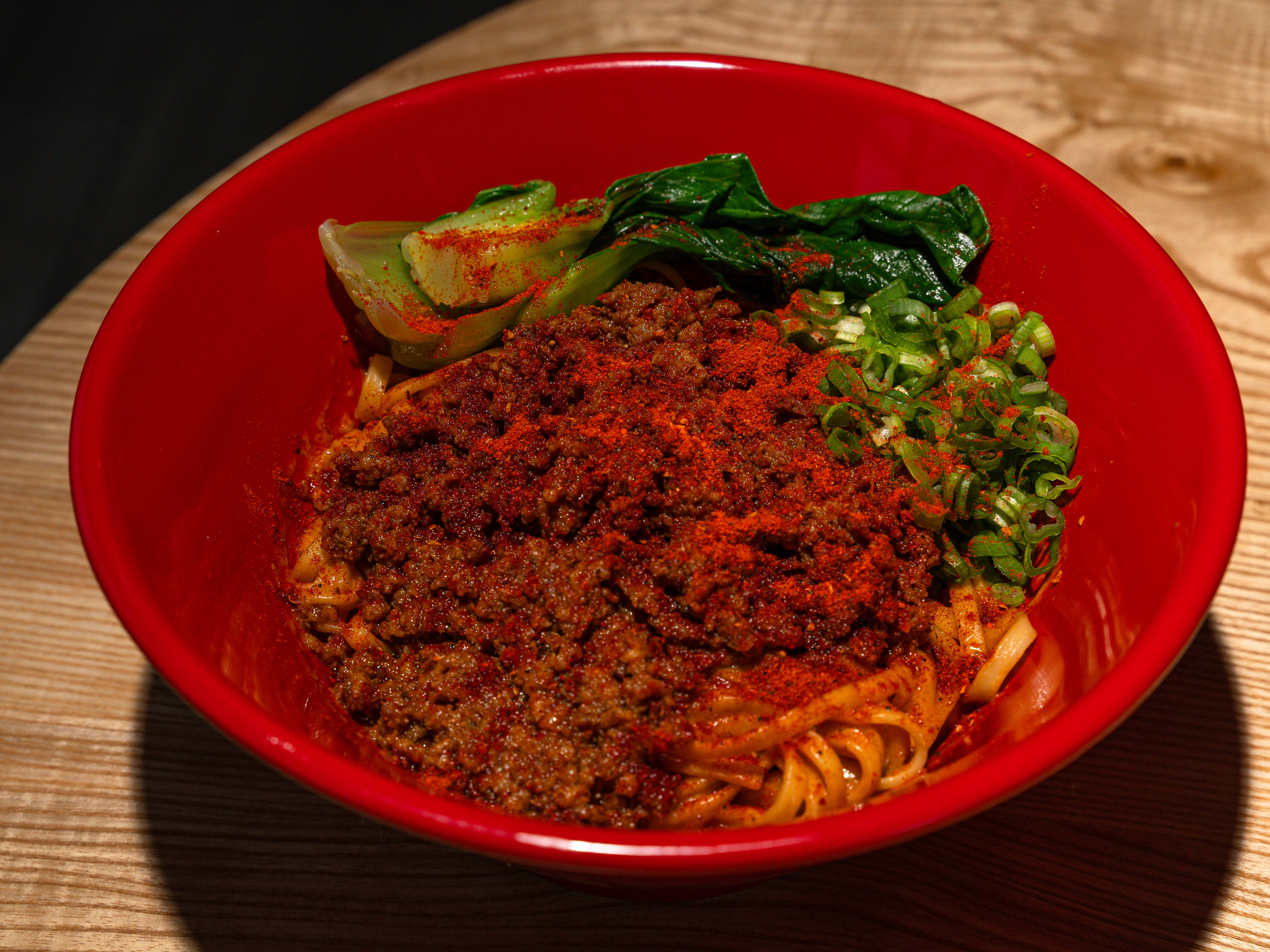 A bowl of soupless tantanmen with spicy ground pork, bokchoy, and thin flat noodles.