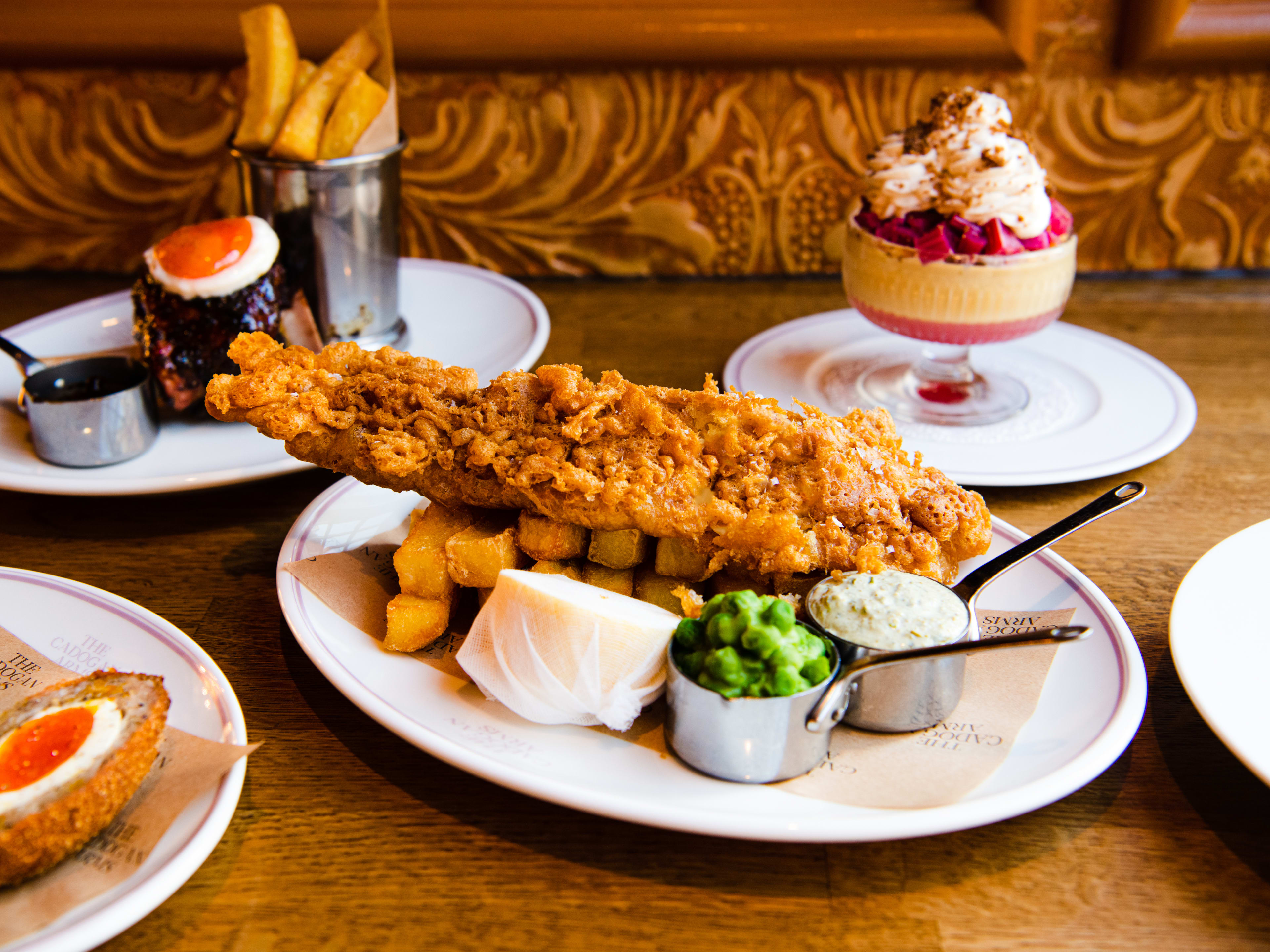 The fish and chips surrounded by other dishes at The Cadogan Arms.