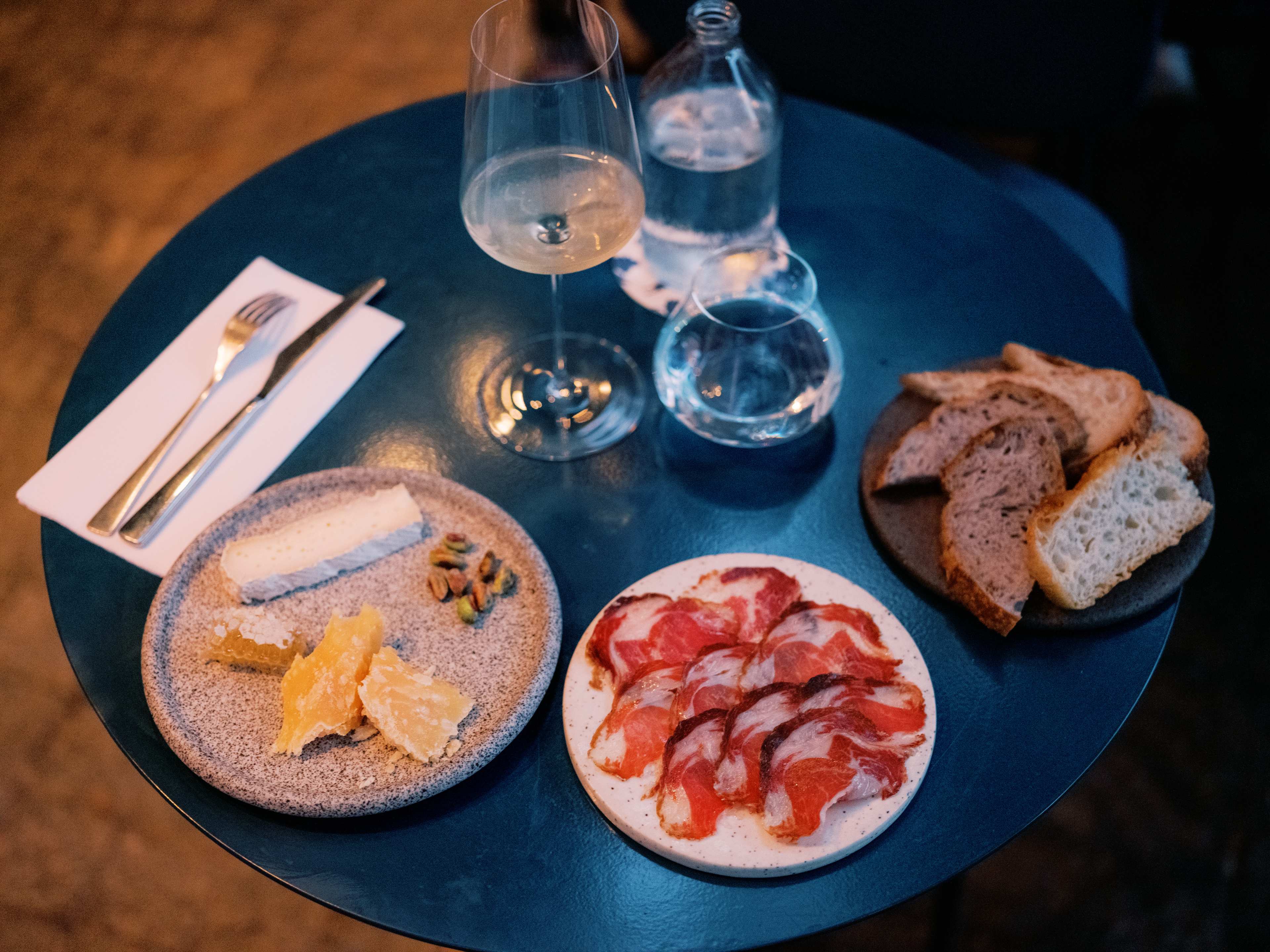 Spread of charcuterie and wine on a bistro table,