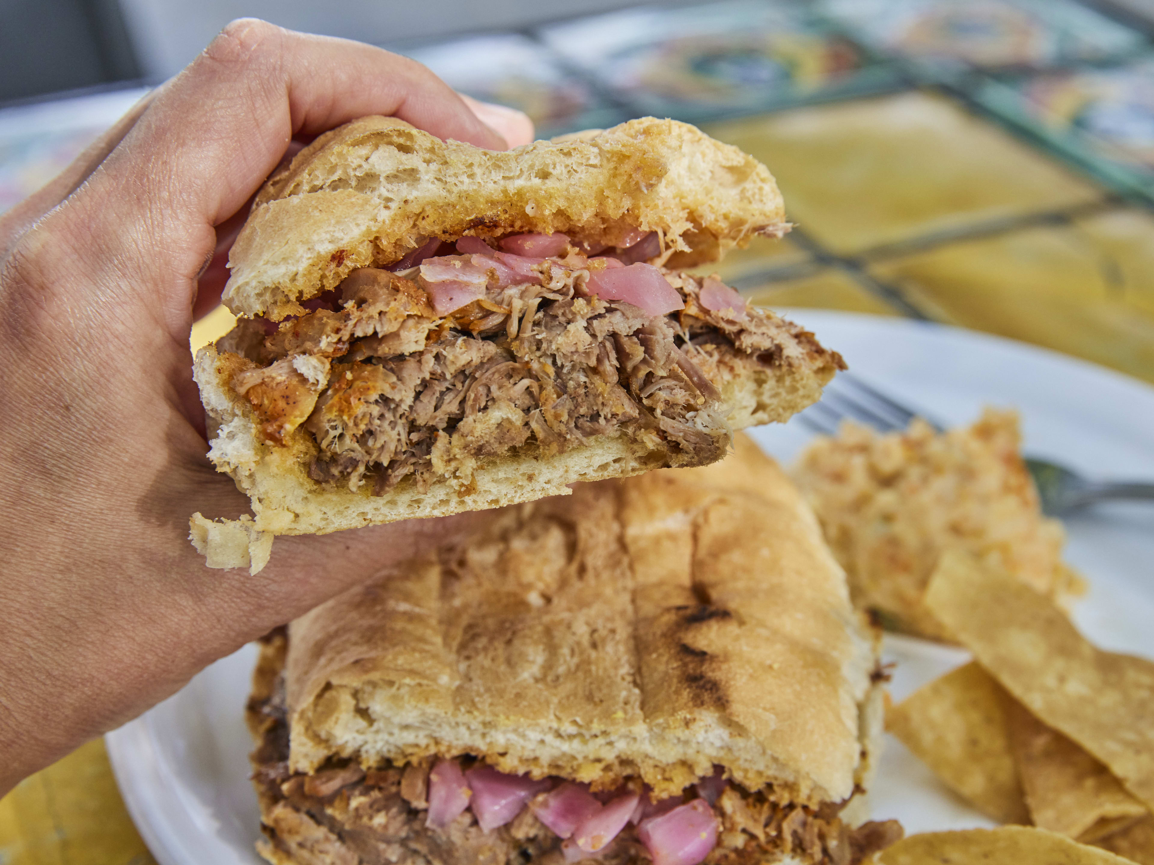 Person holding up half a torta from it's plate.