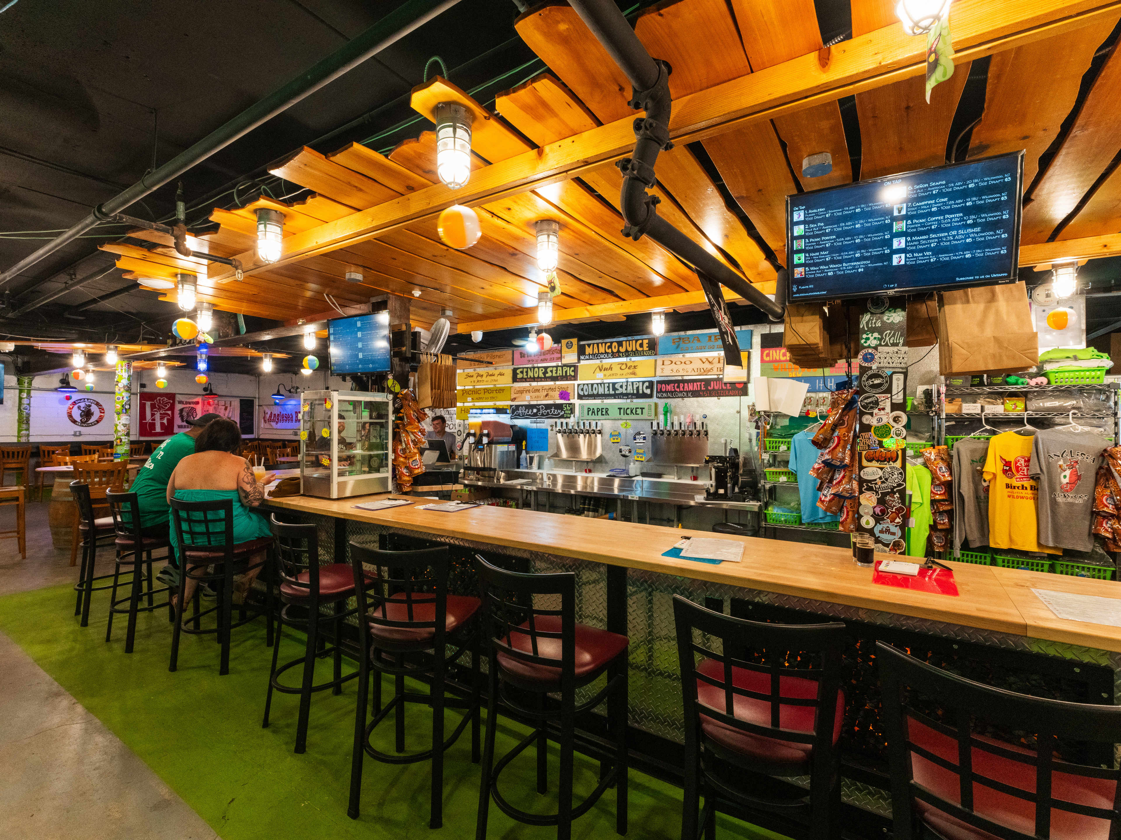 Interior bar area with wooden counterops, ceiling and faux grass.