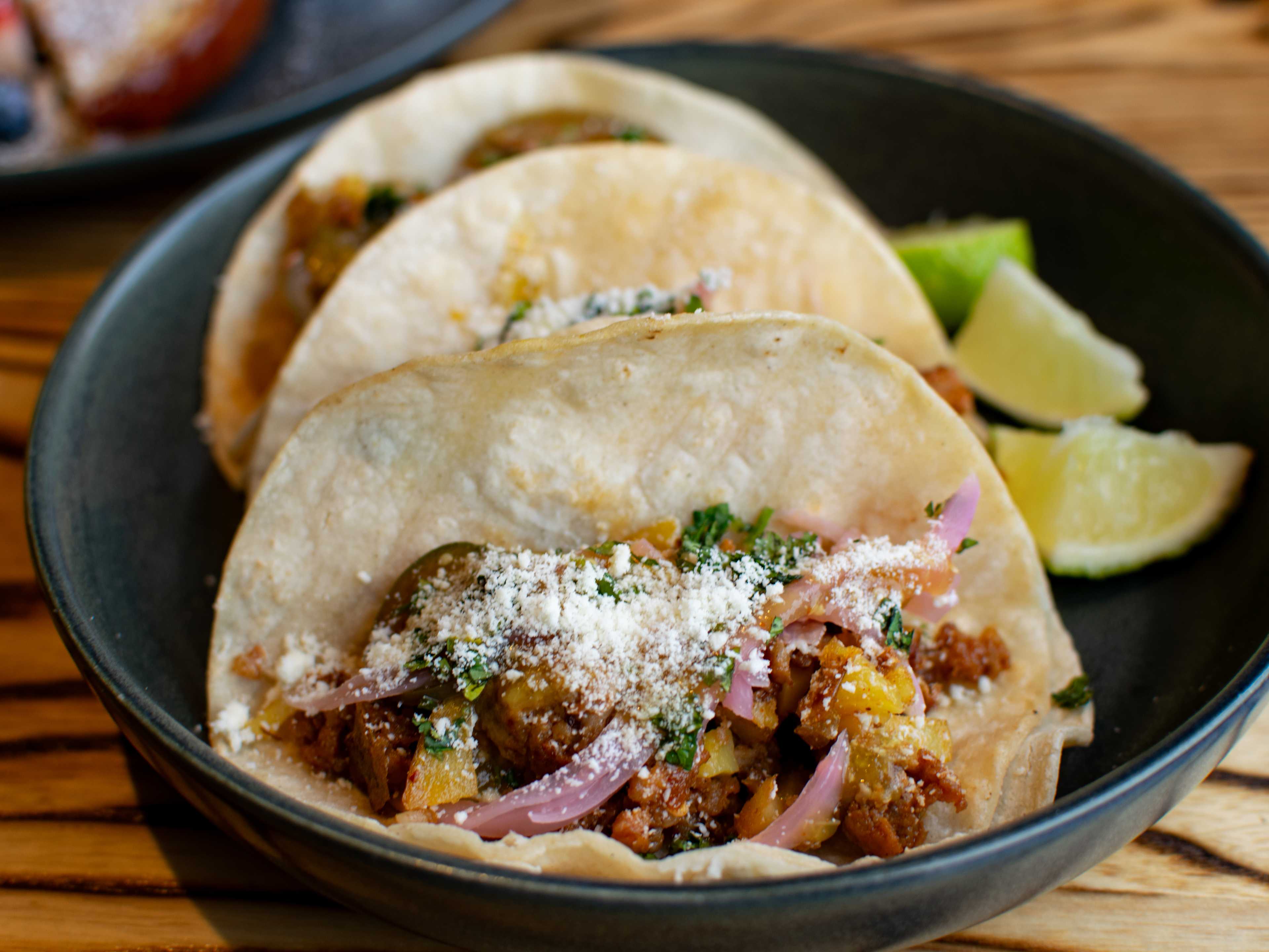 Breakfast tacos in a black bowl.