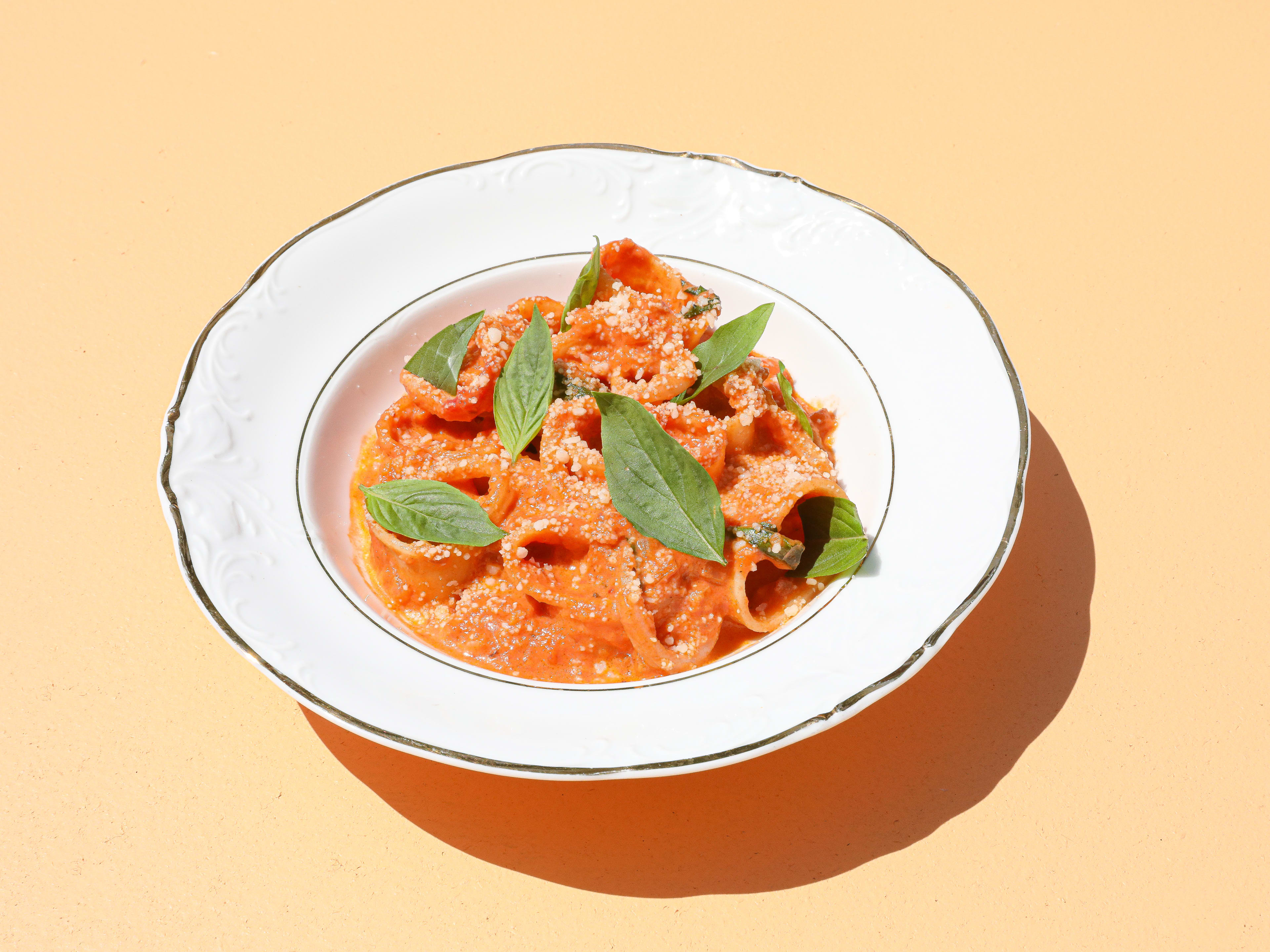 squid with vodka sauce and basil leaves in bowl