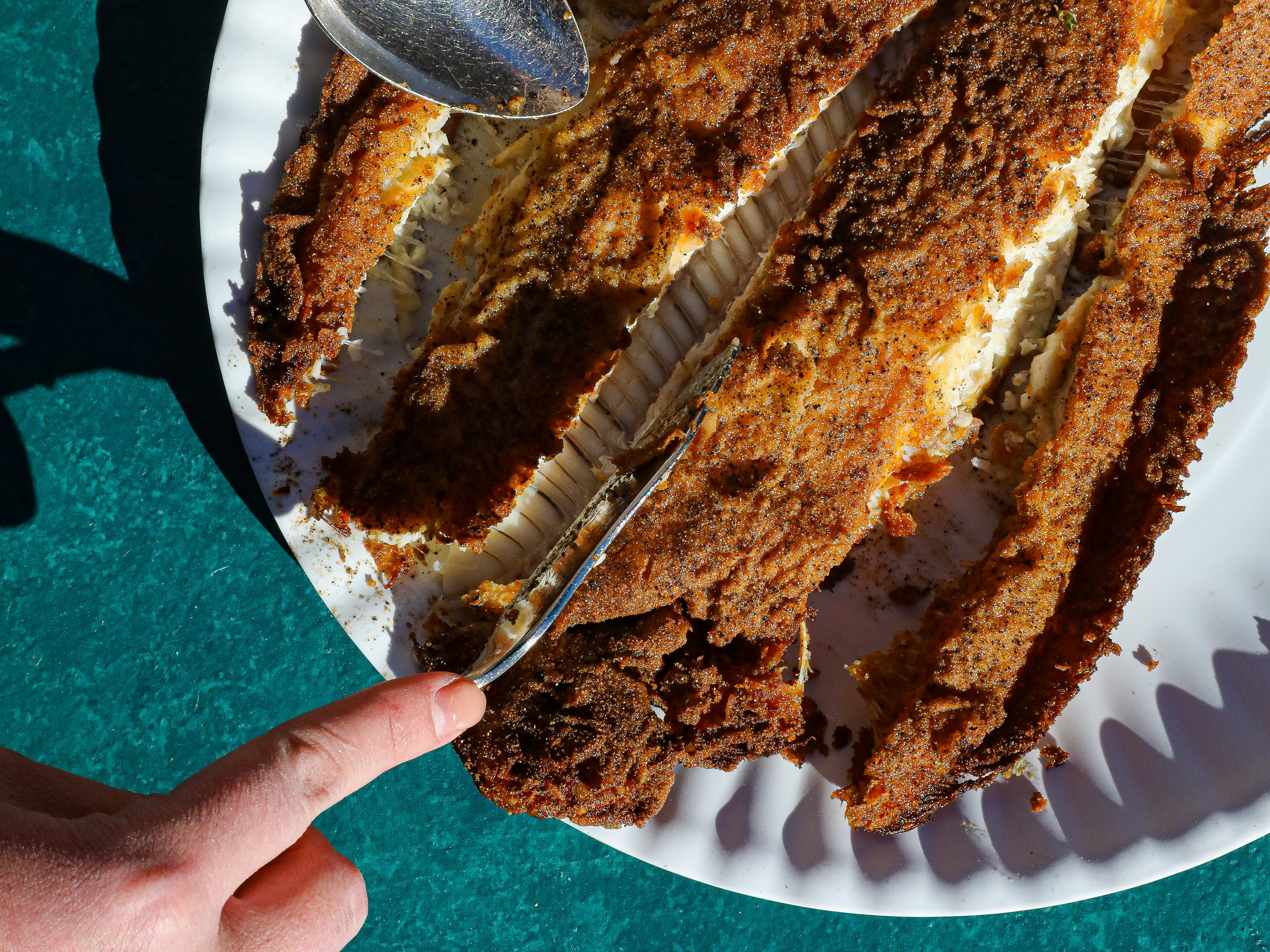 crispy whole fried fish being cut open